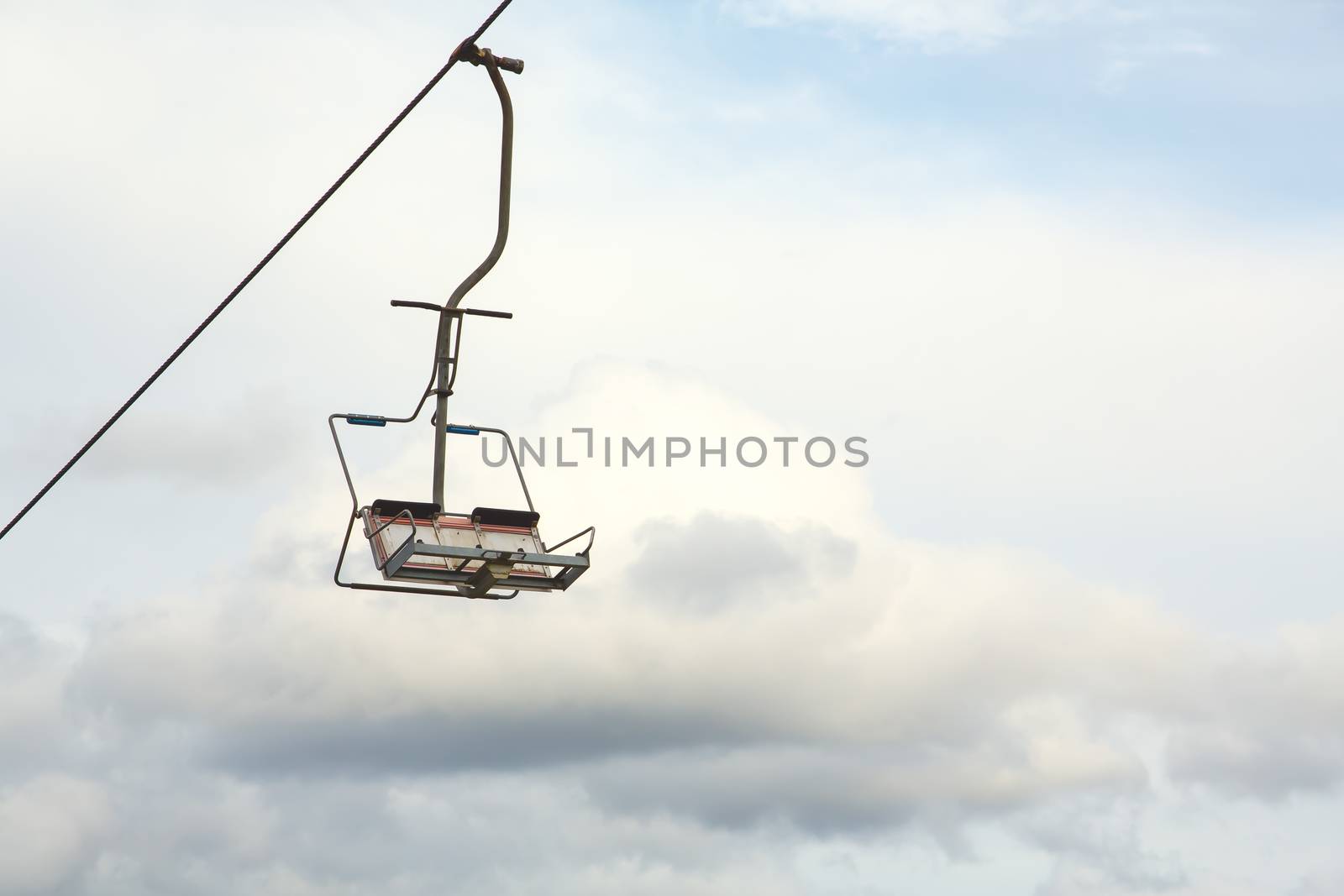 Empty chairlift with cloudy sky in the background by DmitrySteshenko