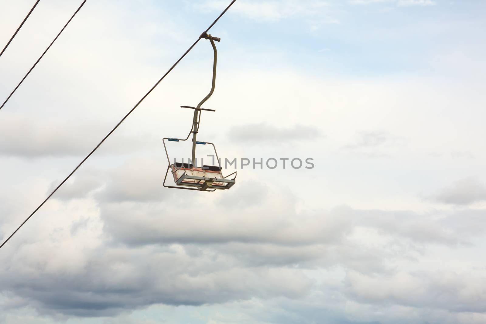 Empty chairlift with cloudy sky in the background by DmitrySteshenko