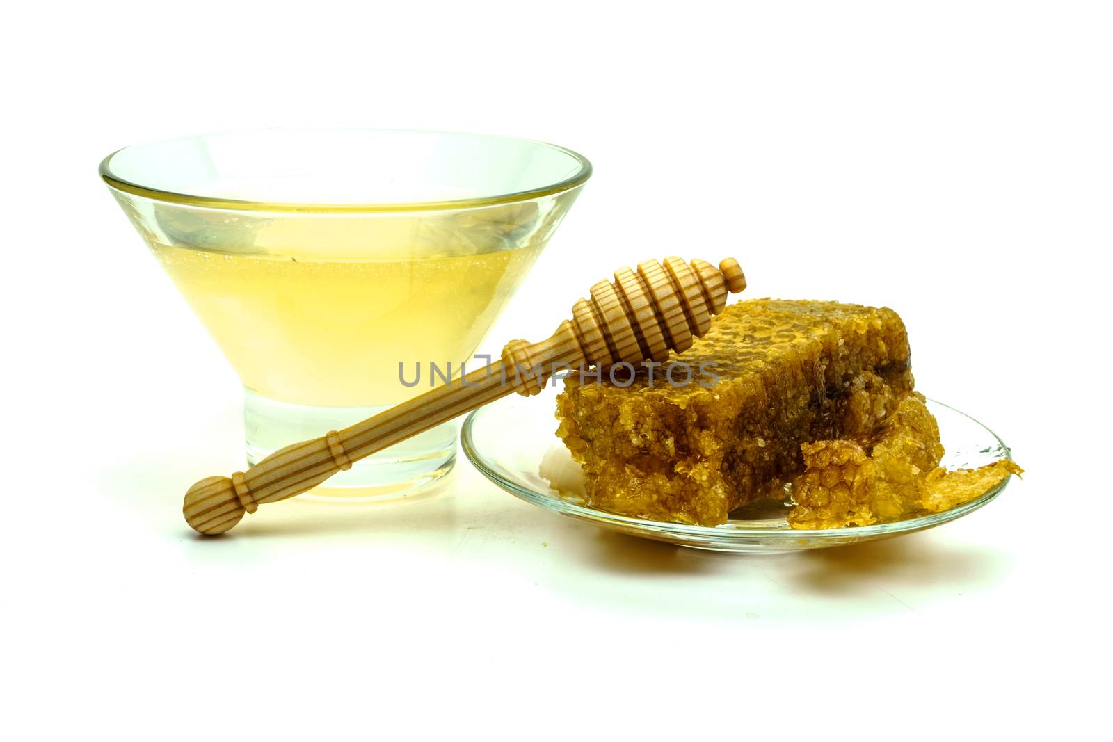 Honey with honeycombs on a glass plate on a white background