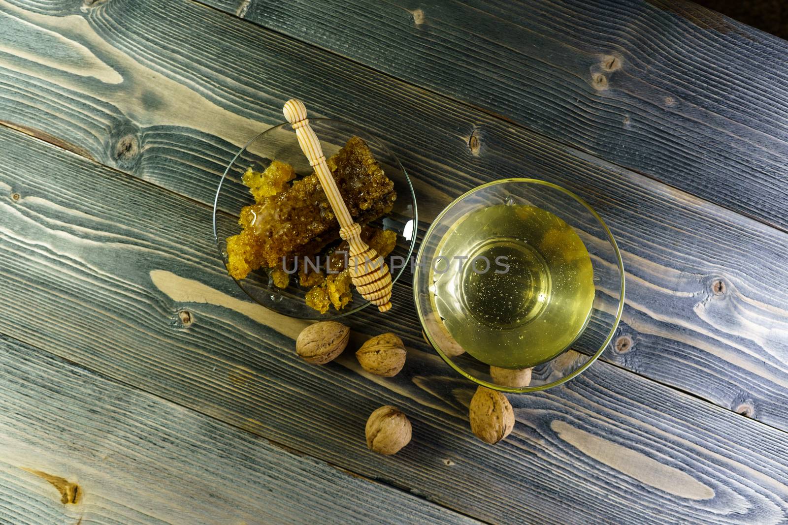 Honey with honeycomb in a glass plate on a wooden table