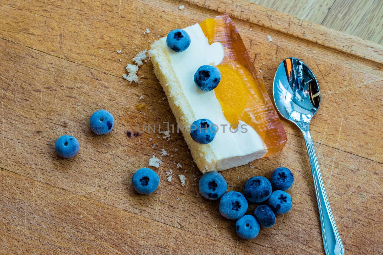 Delicious and sweet cake with blueberries. Sunny dessert on the kitchen table. Light background.