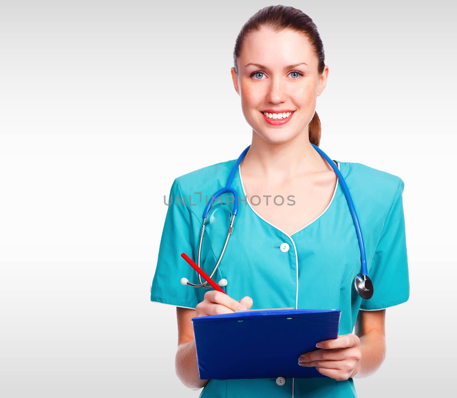 Pretty doctor woman against a grey background with copyspace