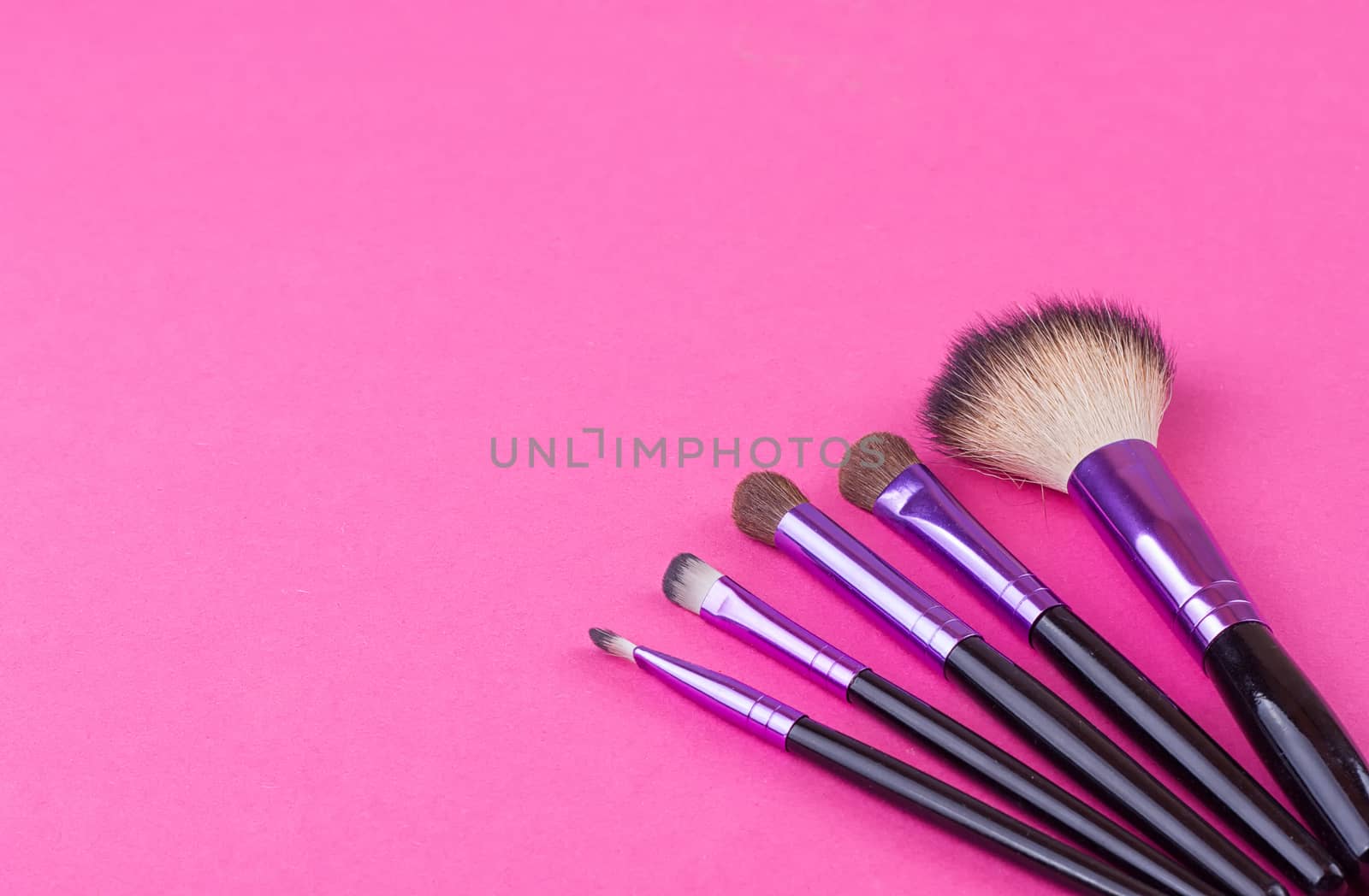 Set of makeup brushes on pink background. Top view point, flat lay.