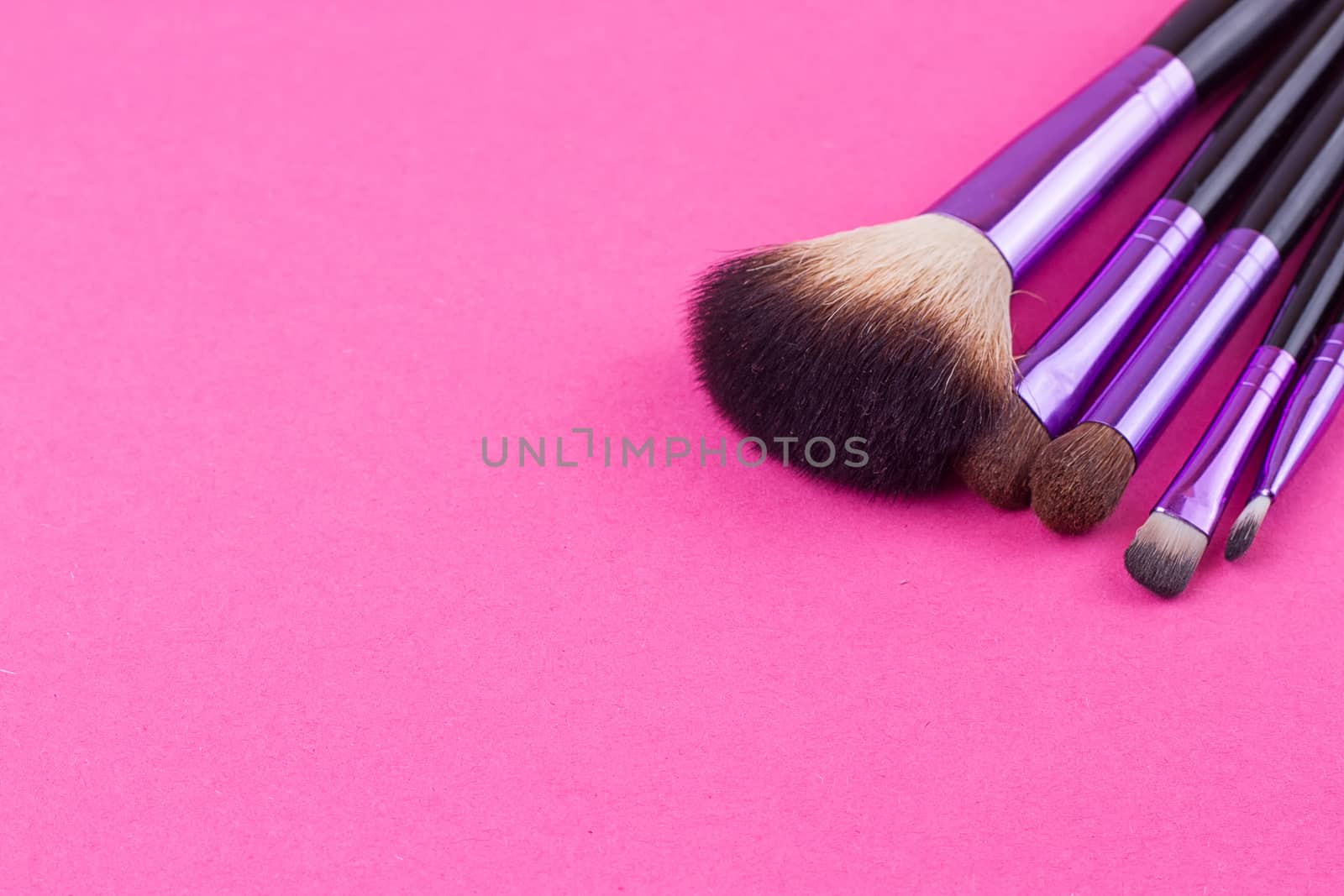 Set of makeup brushes on pink background. Top view point, flat lay.