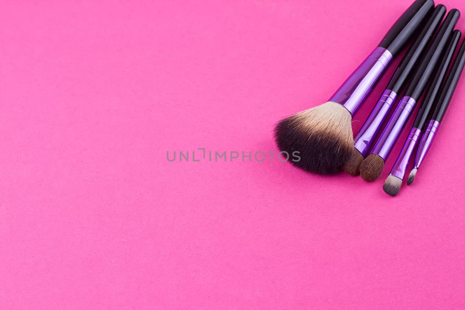 Set of makeup brushes on pink background. Top view point, flat lay.