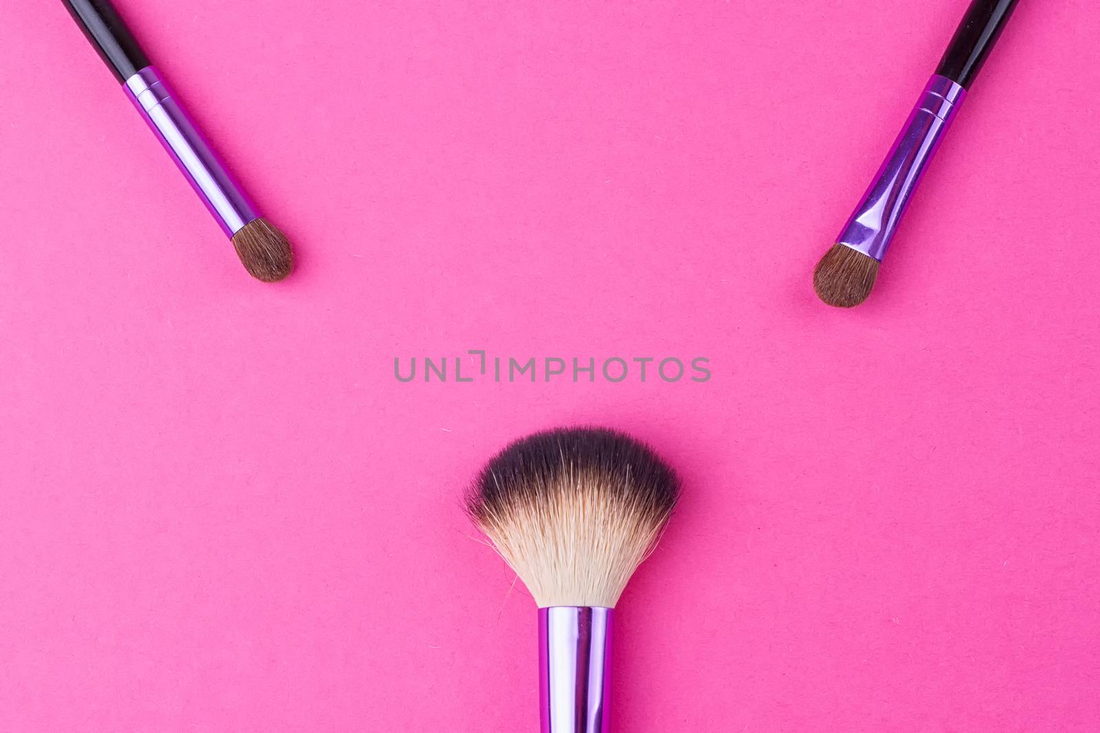 Set of makeup brushes on pink background. Top view point, flat lay.