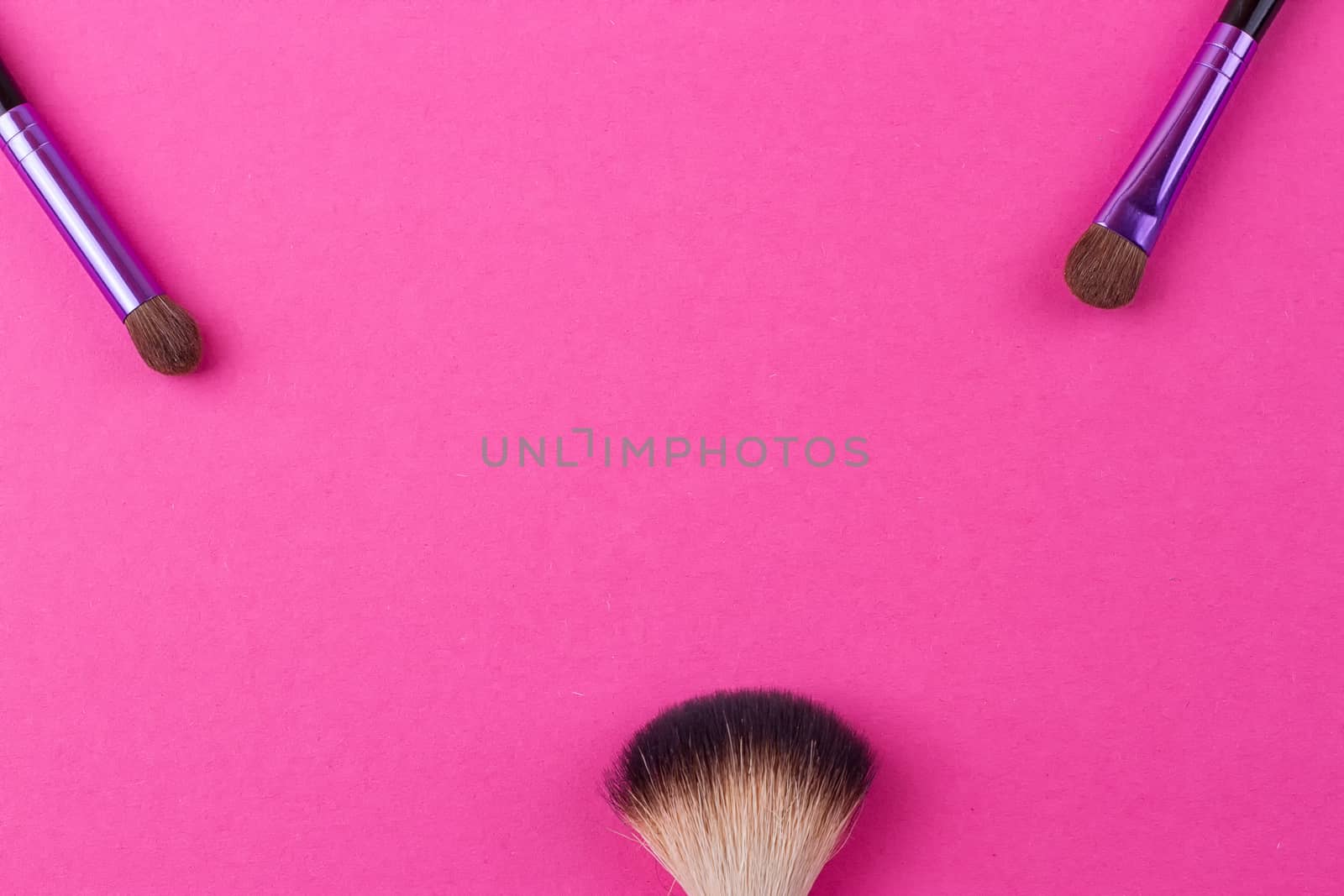 Set of makeup brushes on pink background. Top view point, flat lay.