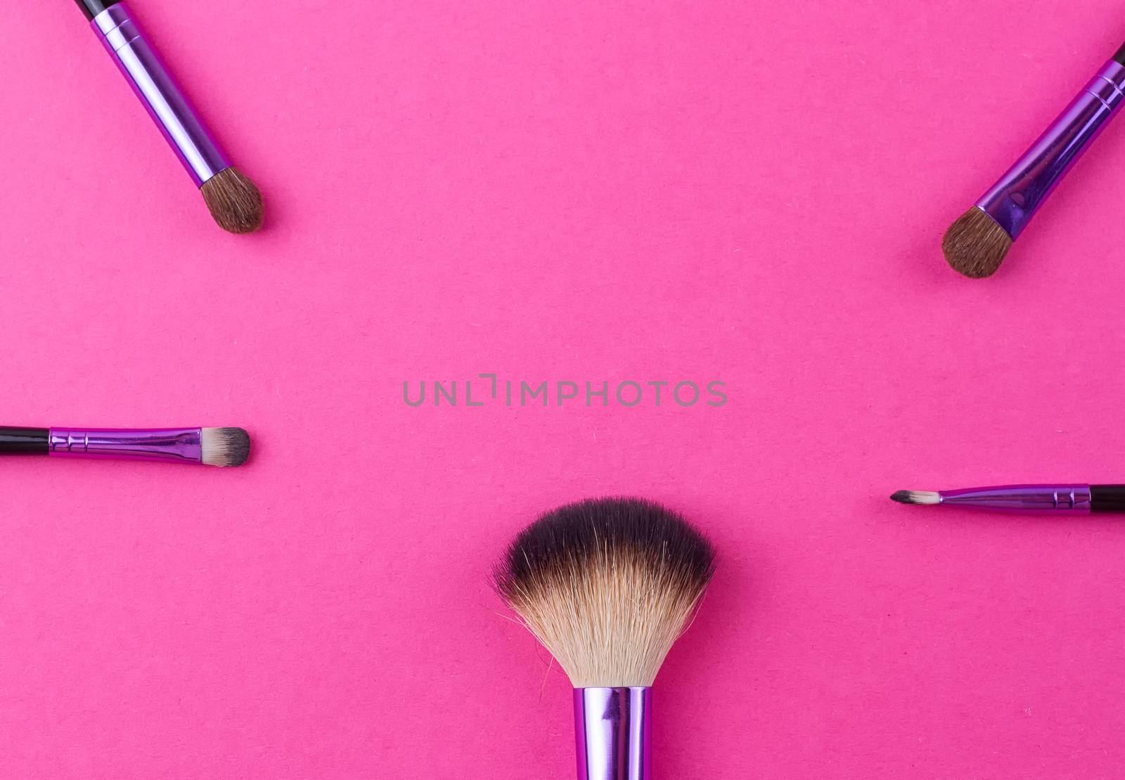 Set of makeup brushes on pink background. Top view point, flat lay.