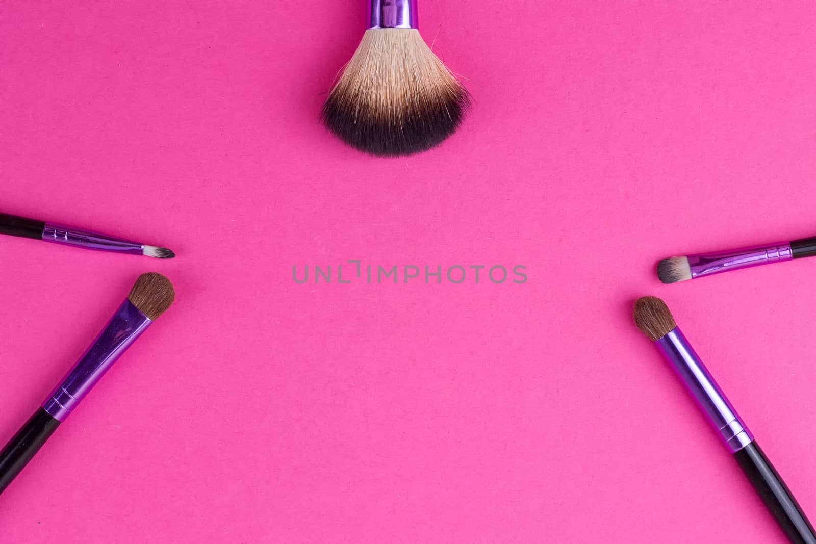 Set of makeup brushes on pink background. Top view point, flat lay.