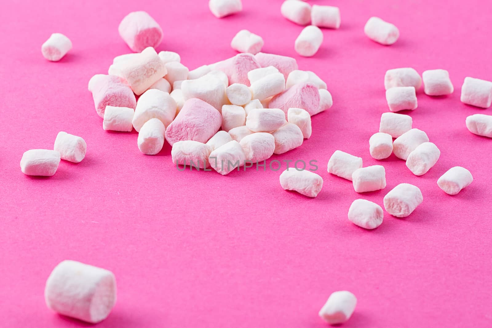 Colored twisted marshmallow on the pink background