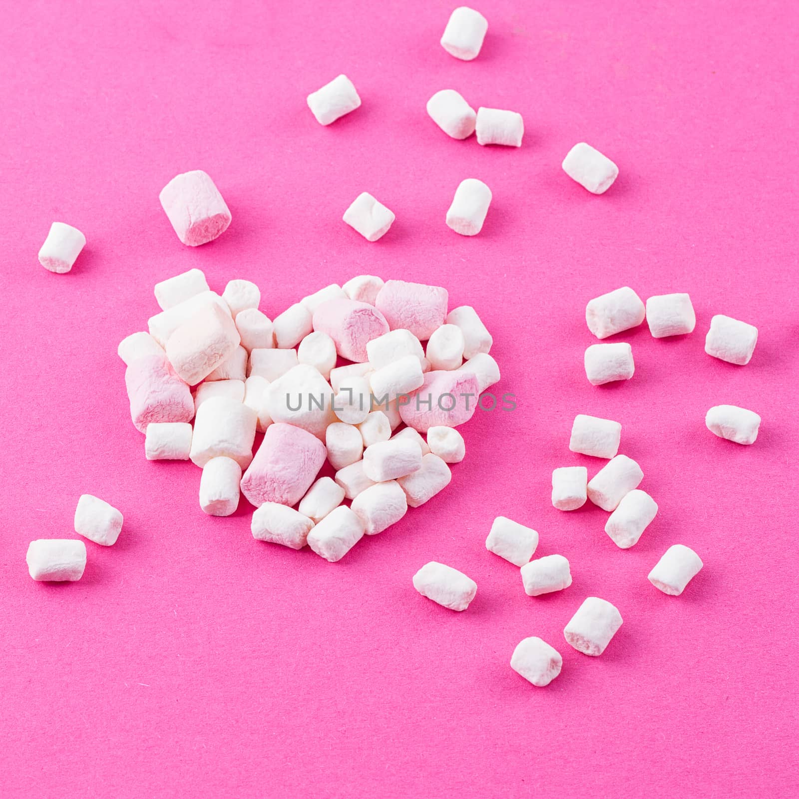 Colored twisted marshmallow on the pink background