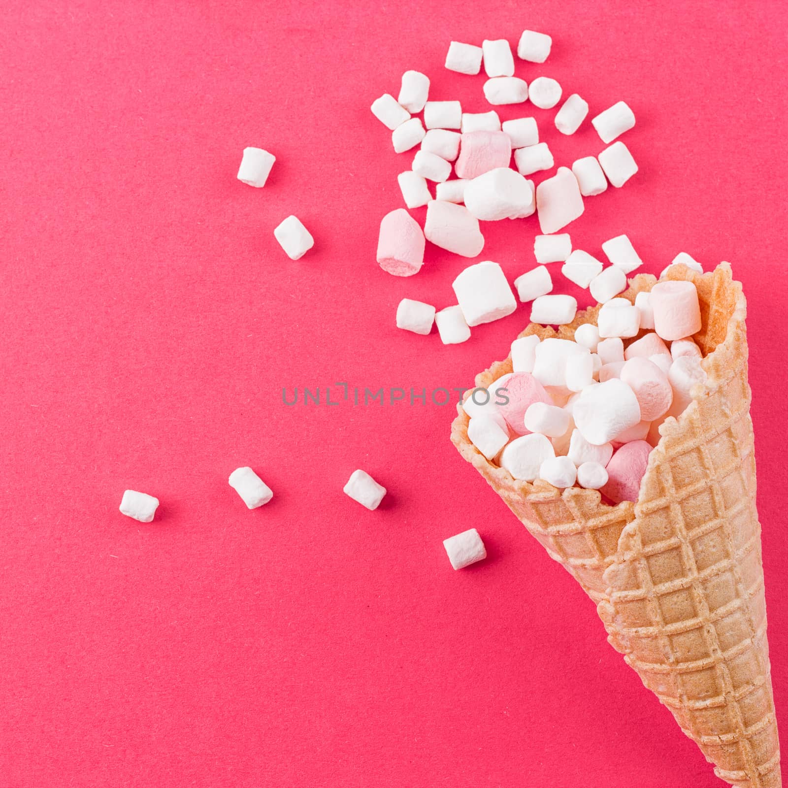 Marshmallows ice-cream and waffle cones on a pink background