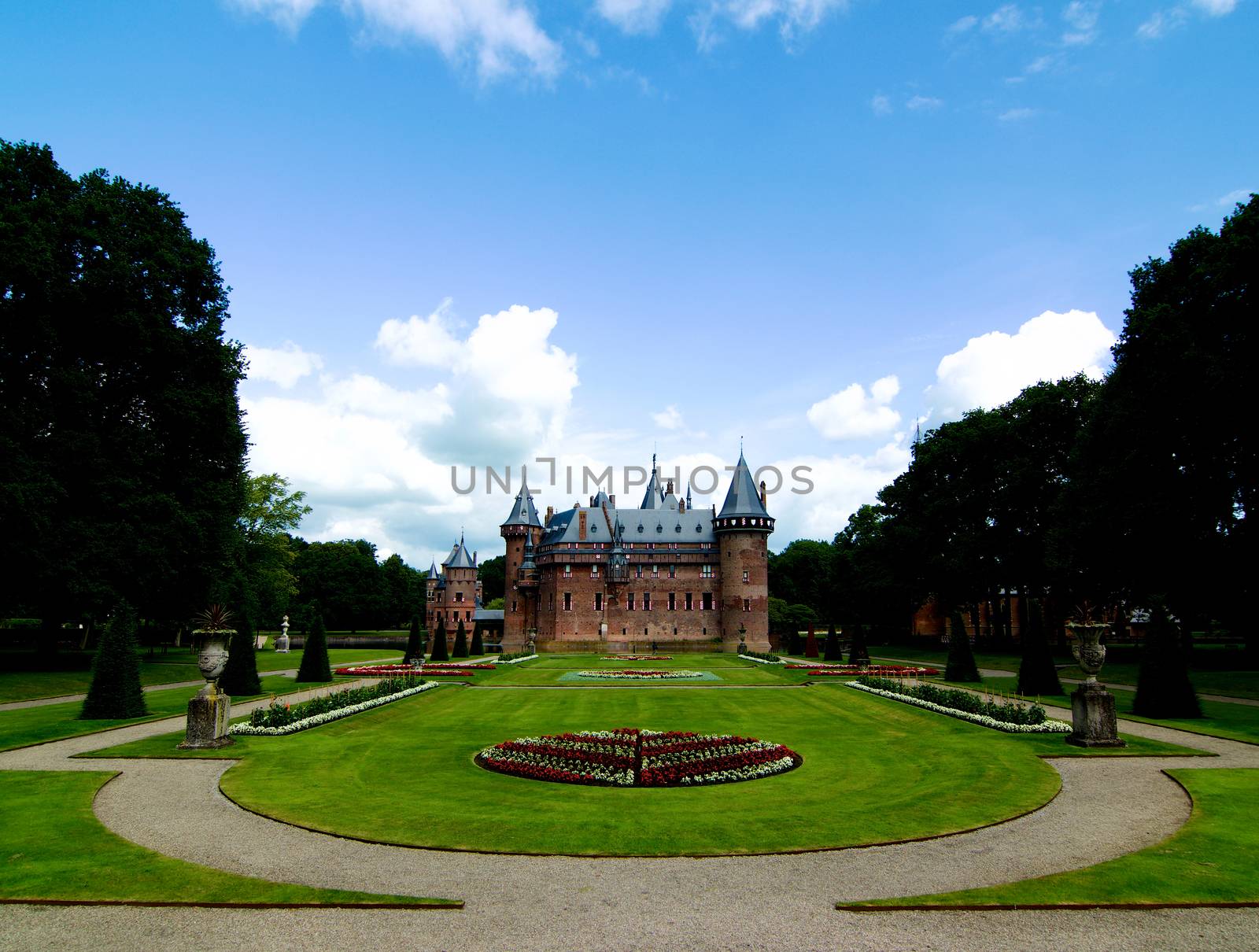 Medieval Castle De Haar from side of Flower Garden Alley against Blue Sky Outdoors. Utrecht, Netherlands