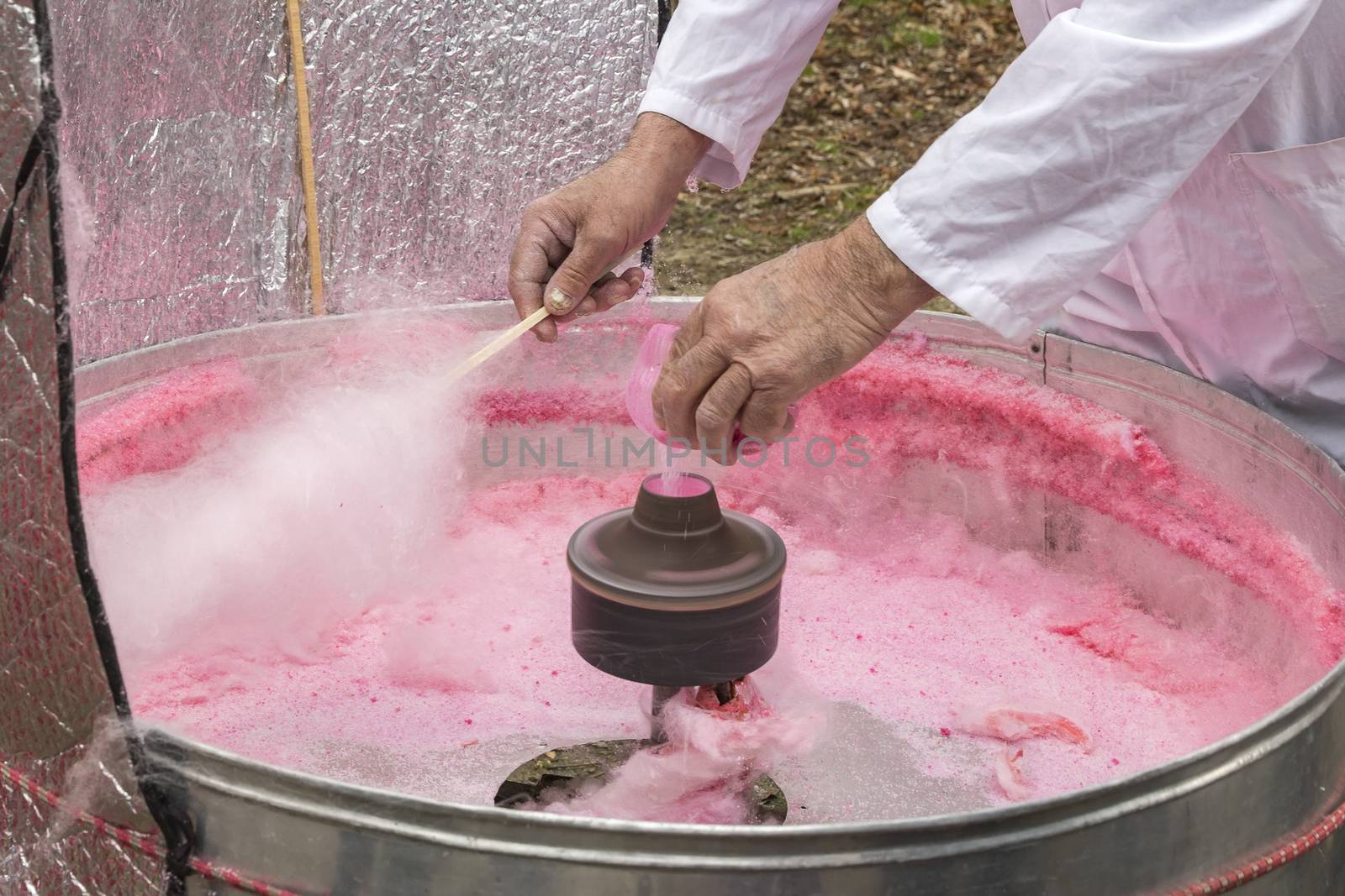 Hand rolling cotton candy in candy floss machine. Making candyfloss.