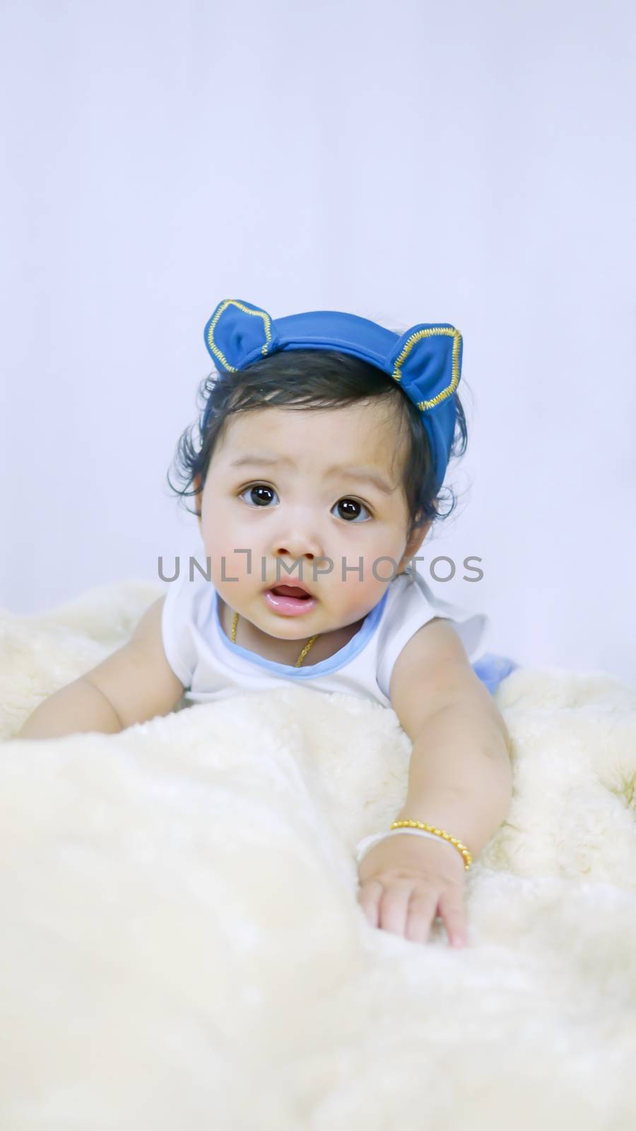 Asian Smiling baby girl crawling in bedroom