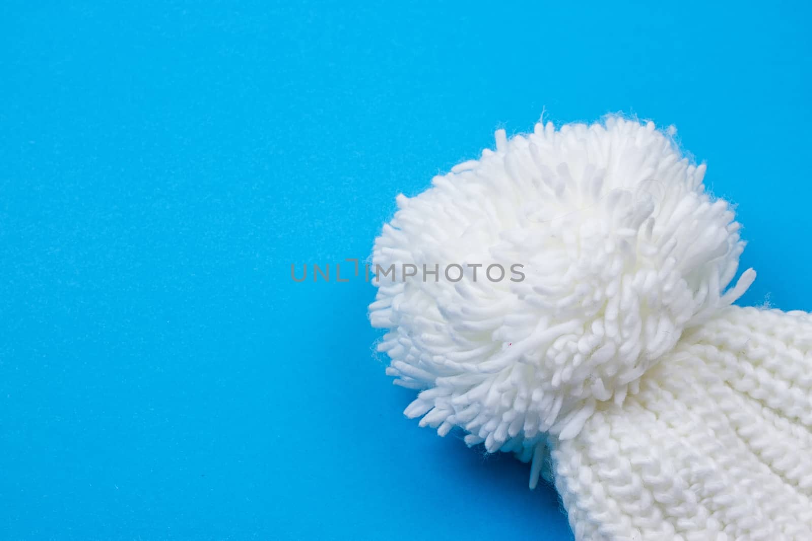 White winter knitted cap on blue background