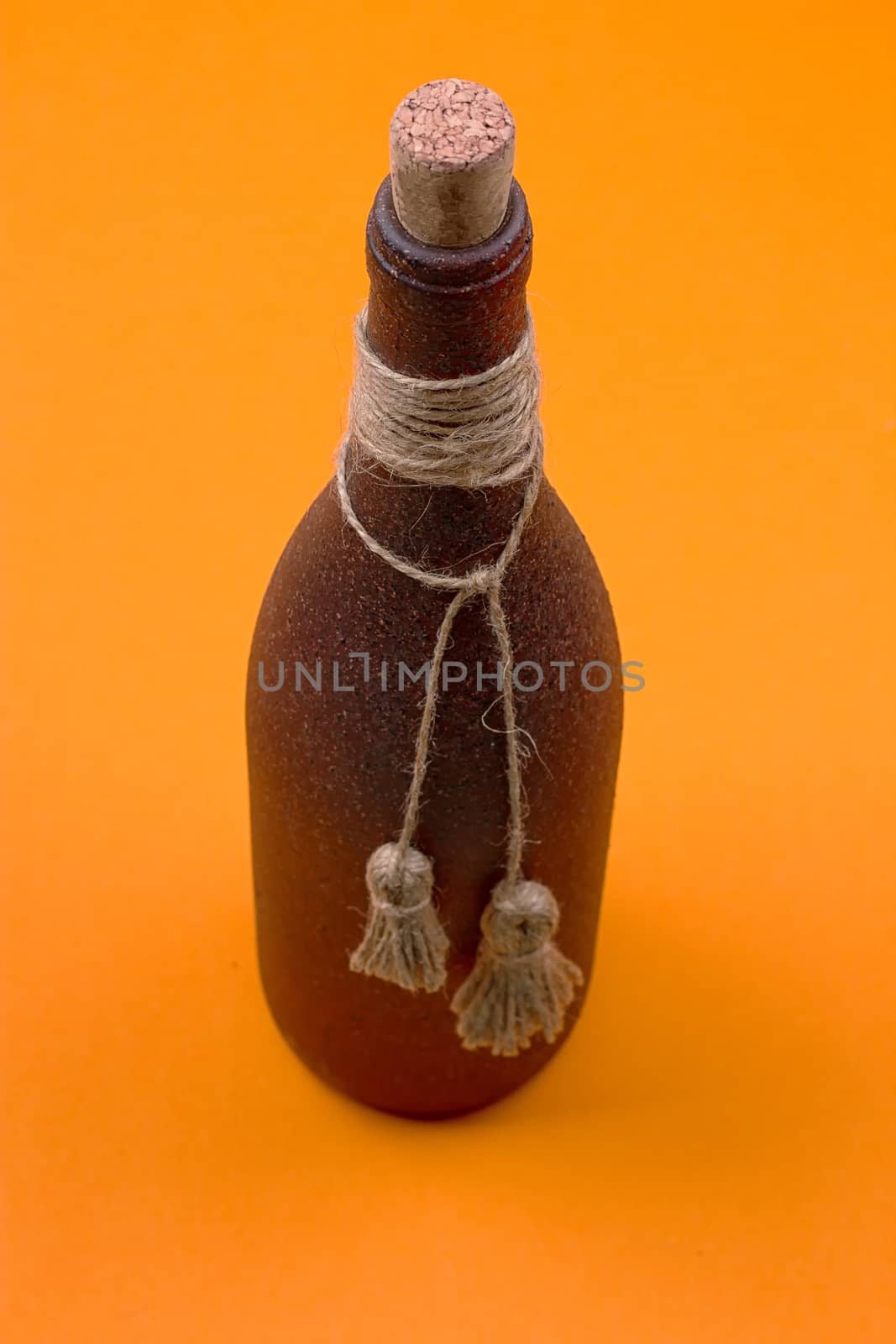 brown bottle made of stone on an orange background