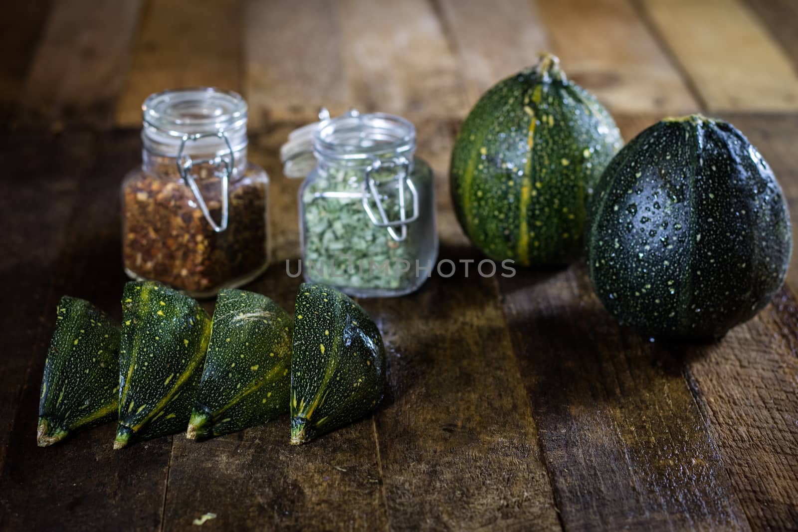 Tasty pumpkin and spices on a wooden kitchen table, black background