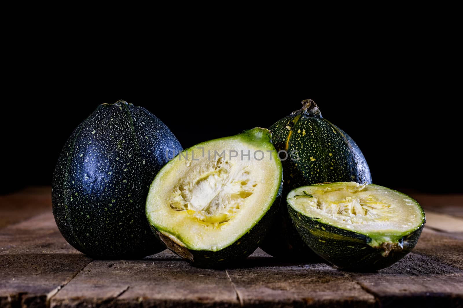 Tasty mini pumpkin on a wooden table, black background