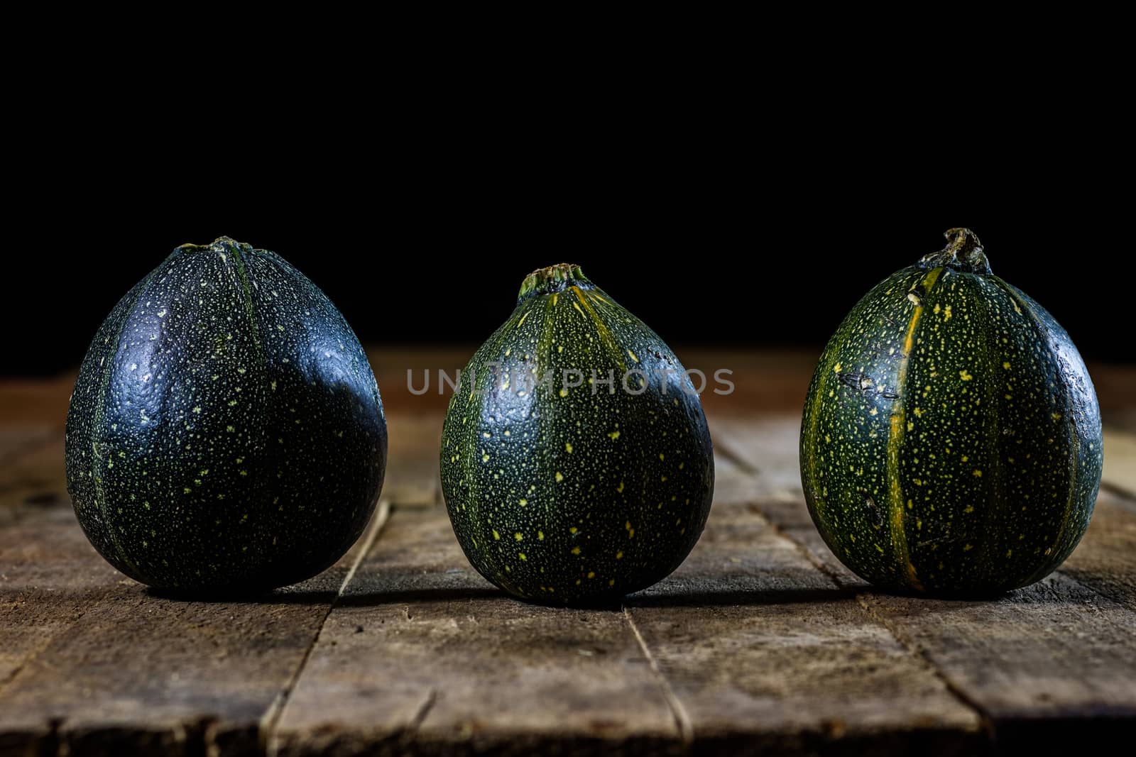 Tasty mini pumpkin on a wooden table, black background