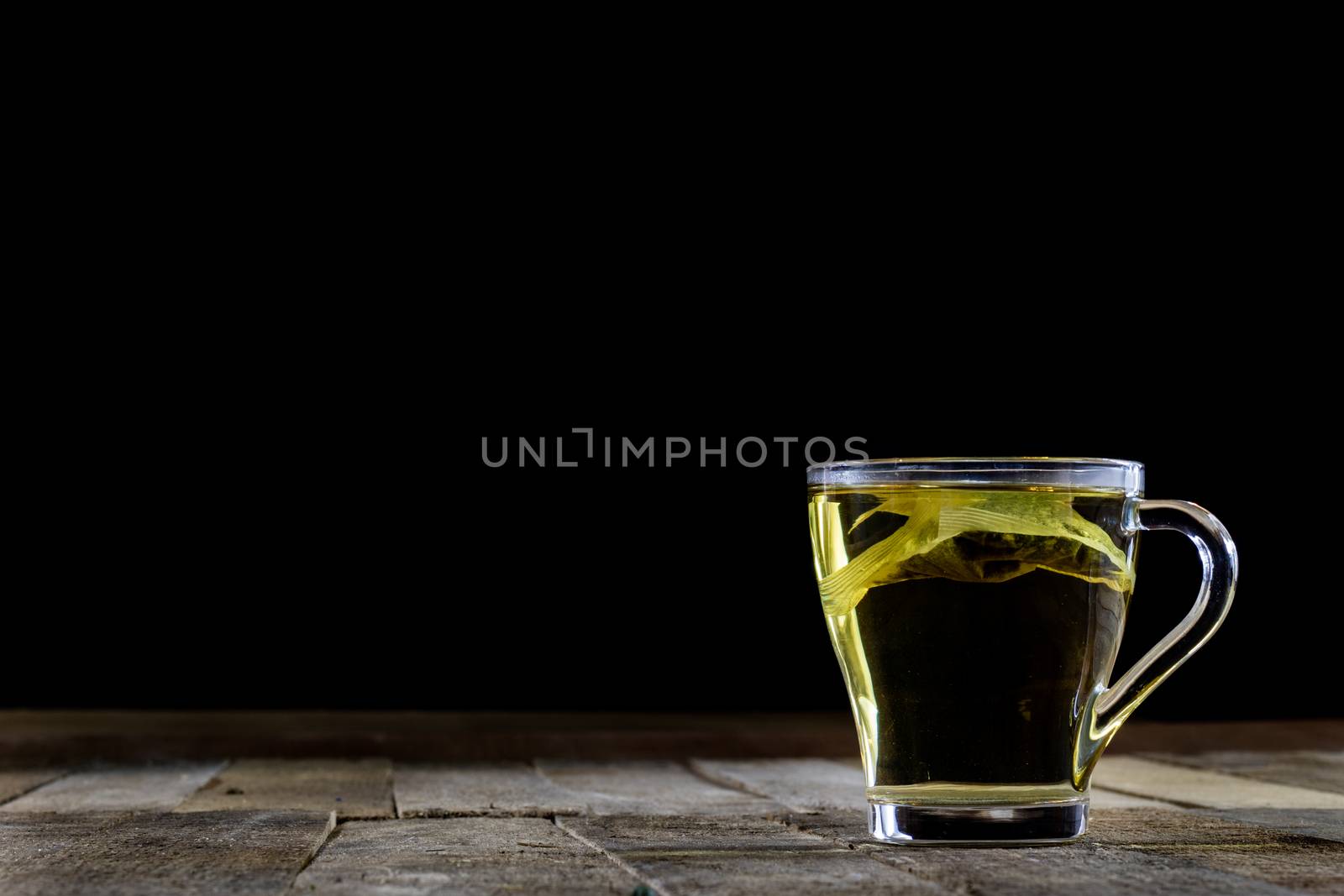 Tasty tea with nettles on a wooden table, black background