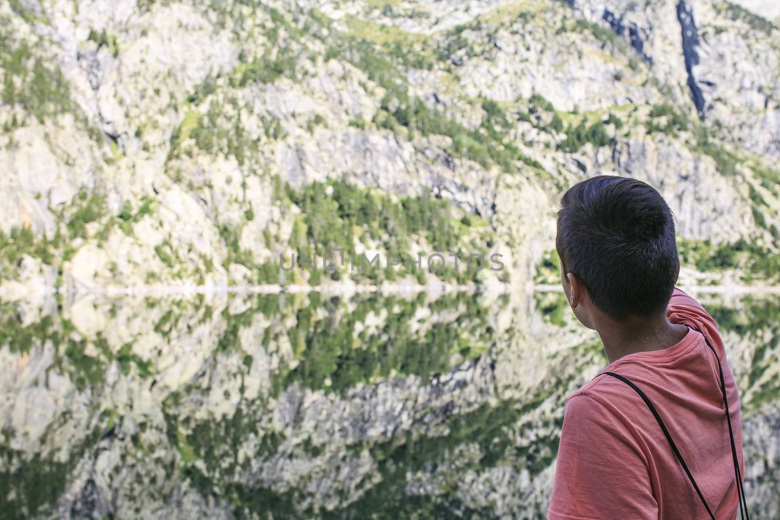 boy  looking at Mountains and lake photo with reflection