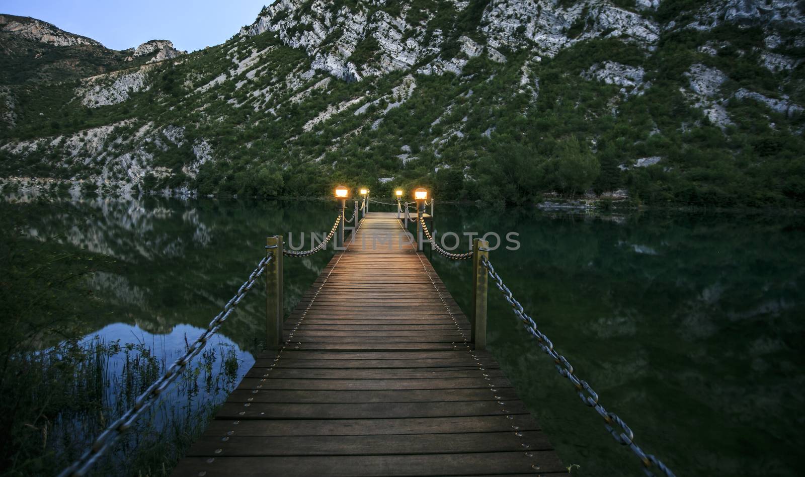 wooden bridge over a lake in the night by nachrc2001
