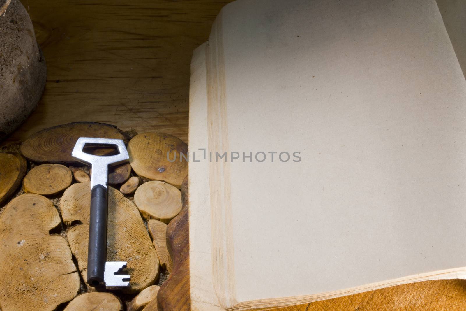 Old book and key on a wooden kitchen table