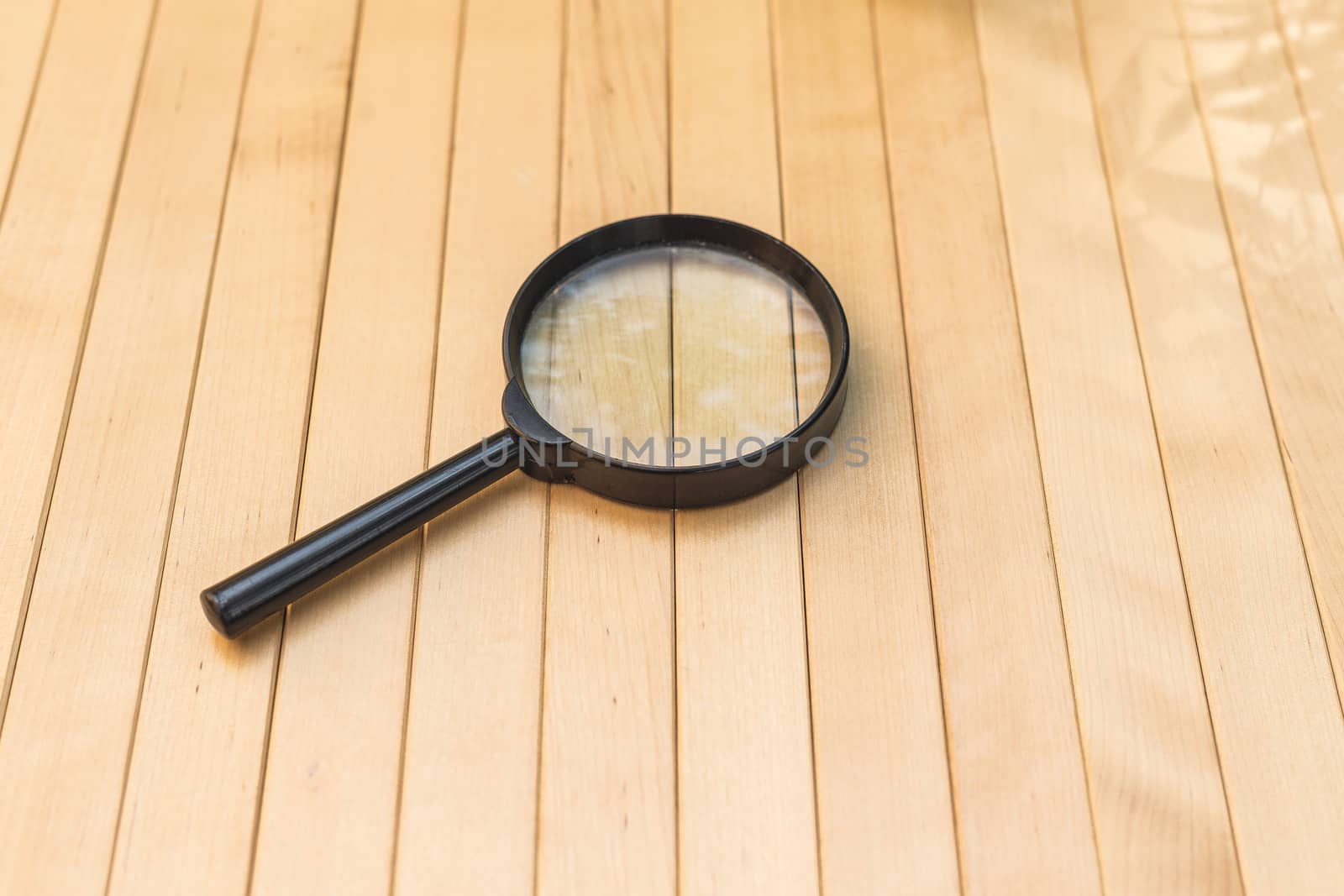 Magnifying glass on wooden background