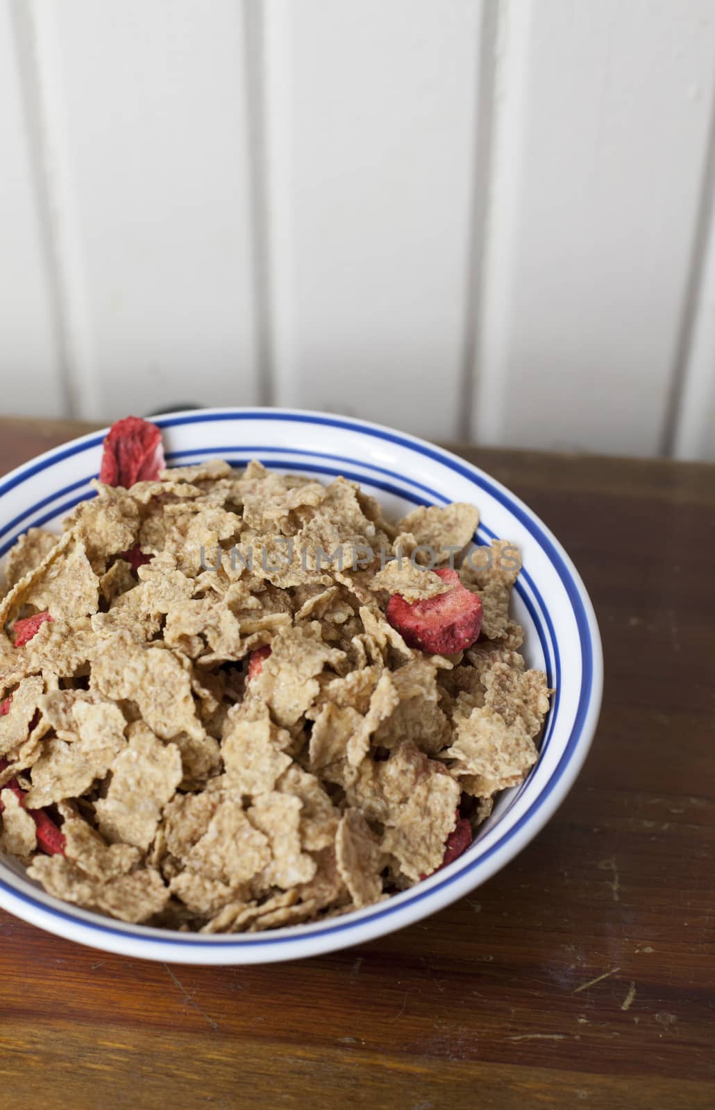 Dry corn flakes with sliced strawberries mixed in