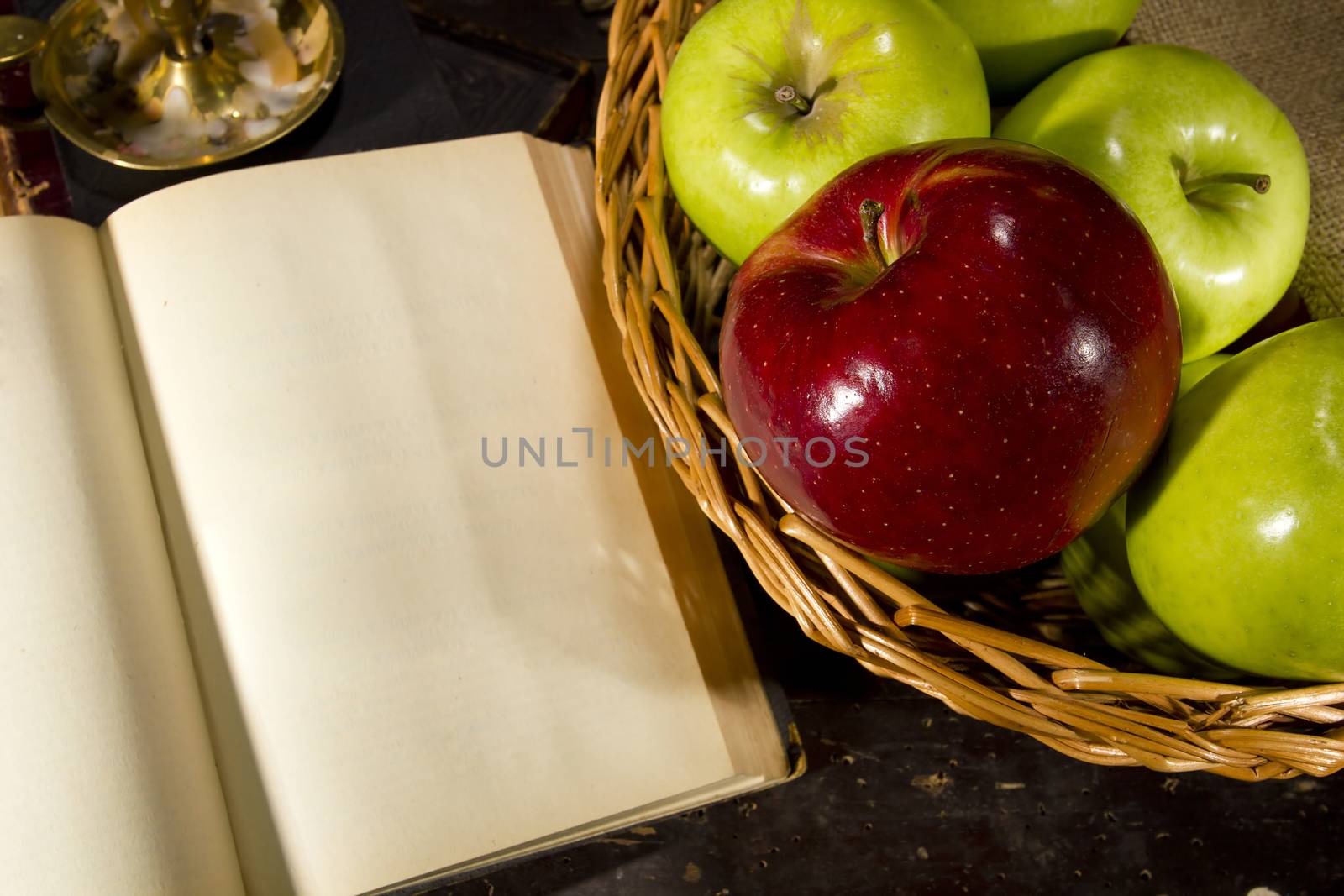 Vintage still life with apples and a book on an old wooden table
