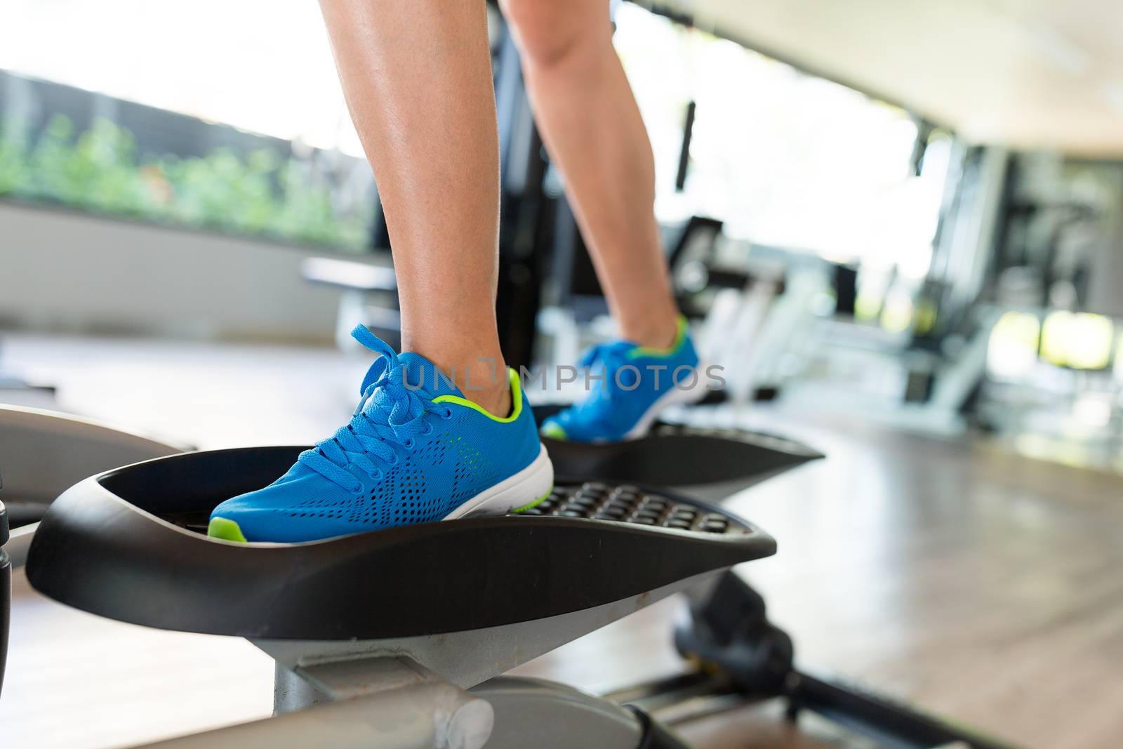 Woman doing exercises in the gym on elliptical cross trainer