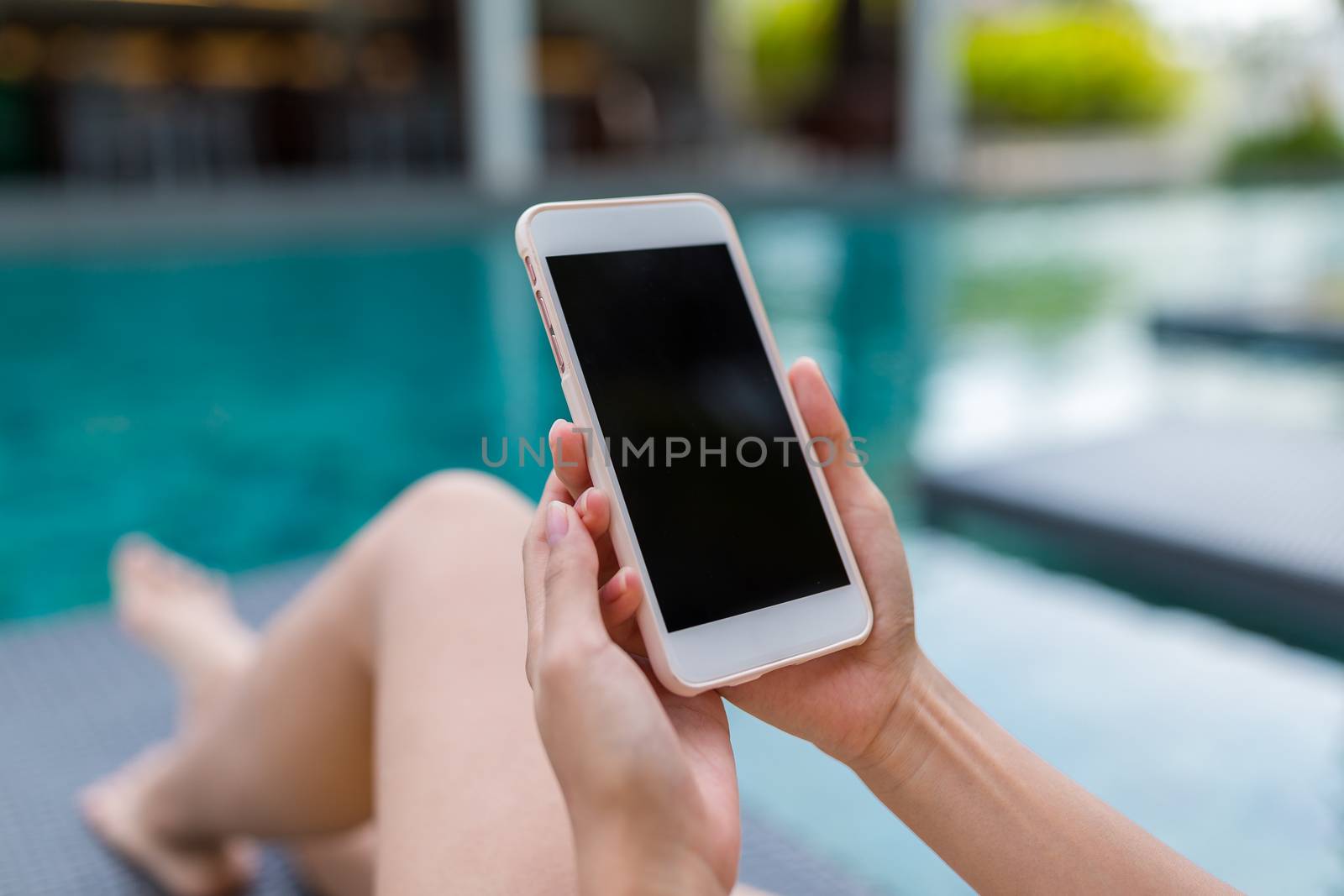 Woman use of cellphone in swimming pool by leungchopan