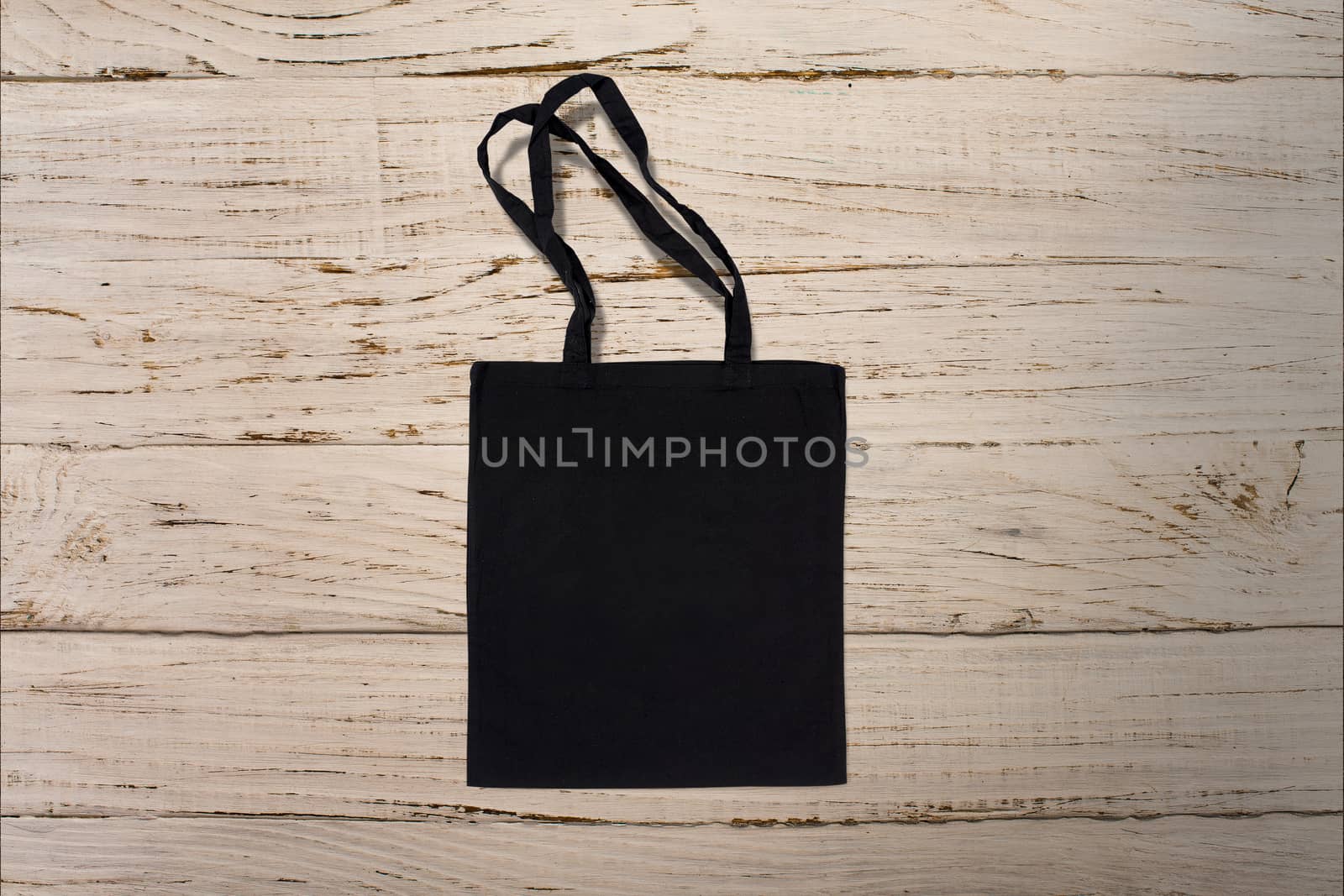 black cotton bag for shopping on a wooden background by boys1983@mail.ru