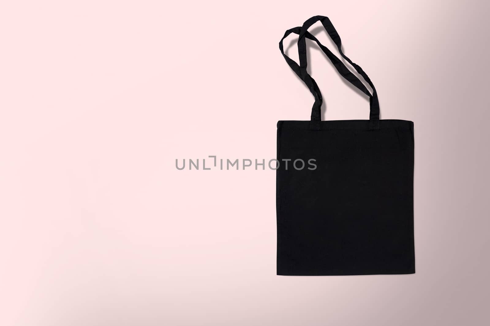 black cotton bag for shopping on a pink background by boys1983@mail.ru
