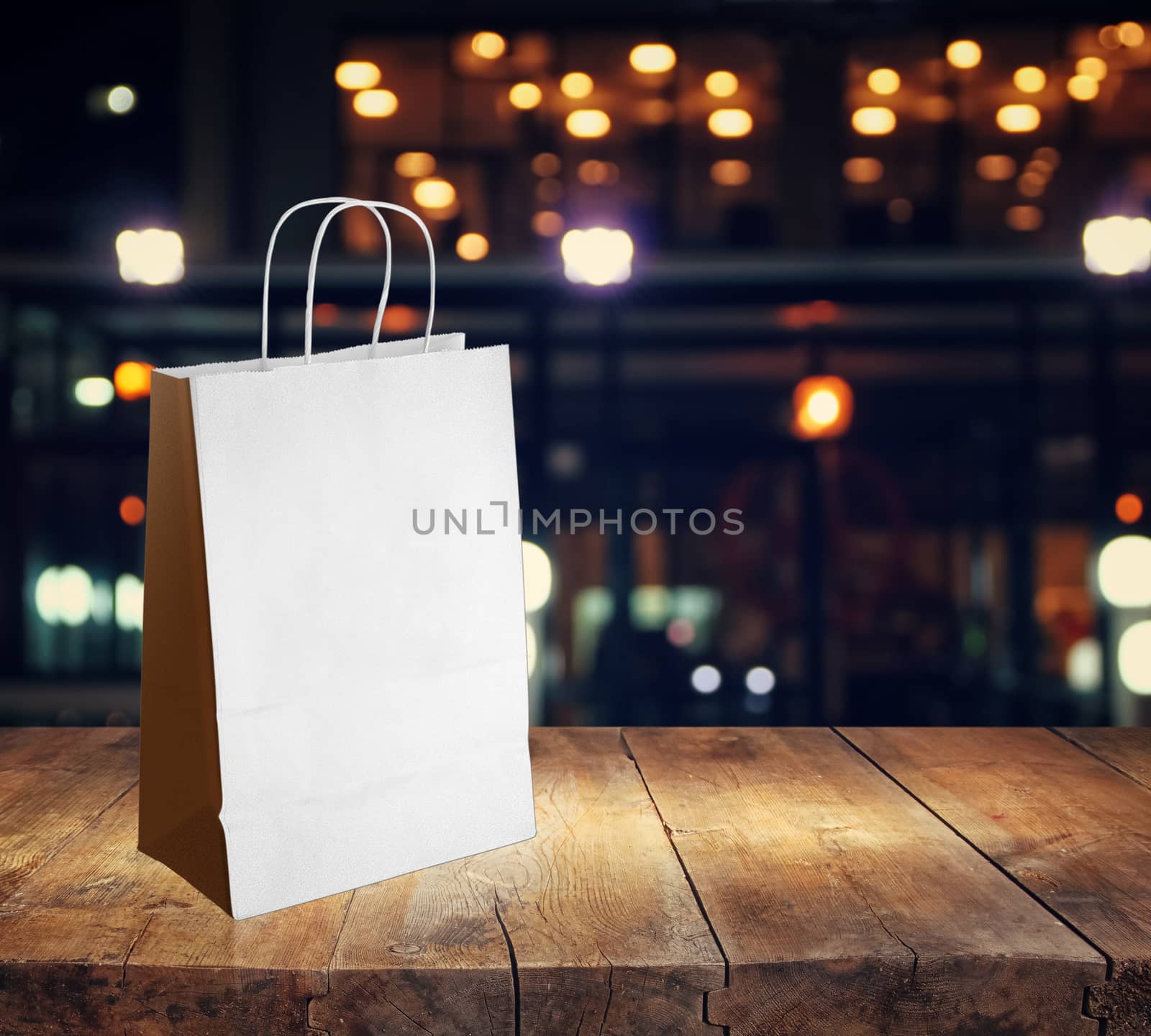 light paper bag for shopping on a wooden background by boys1983@mail.ru