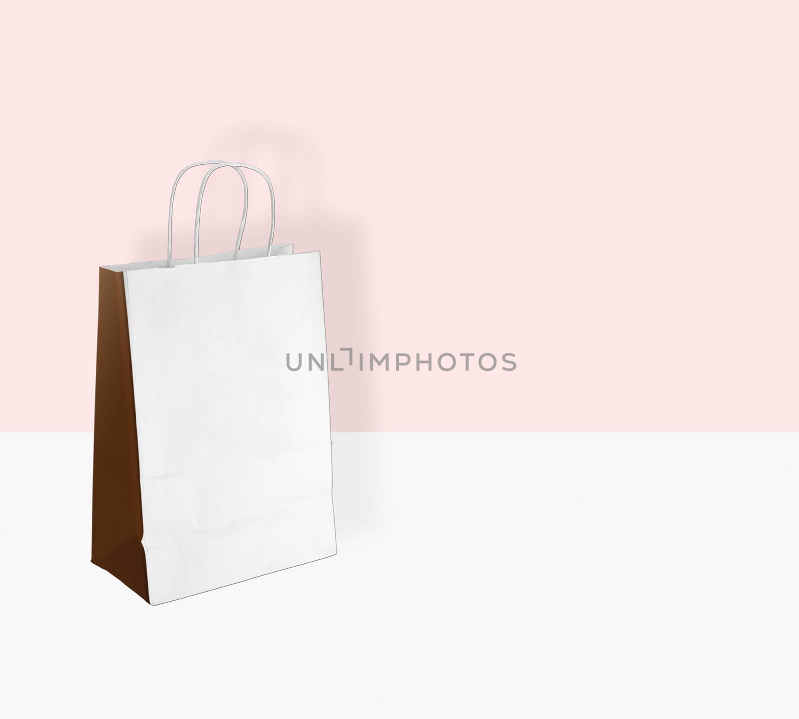 light paper bag for shopping on a pink background by boys1983@mail.ru