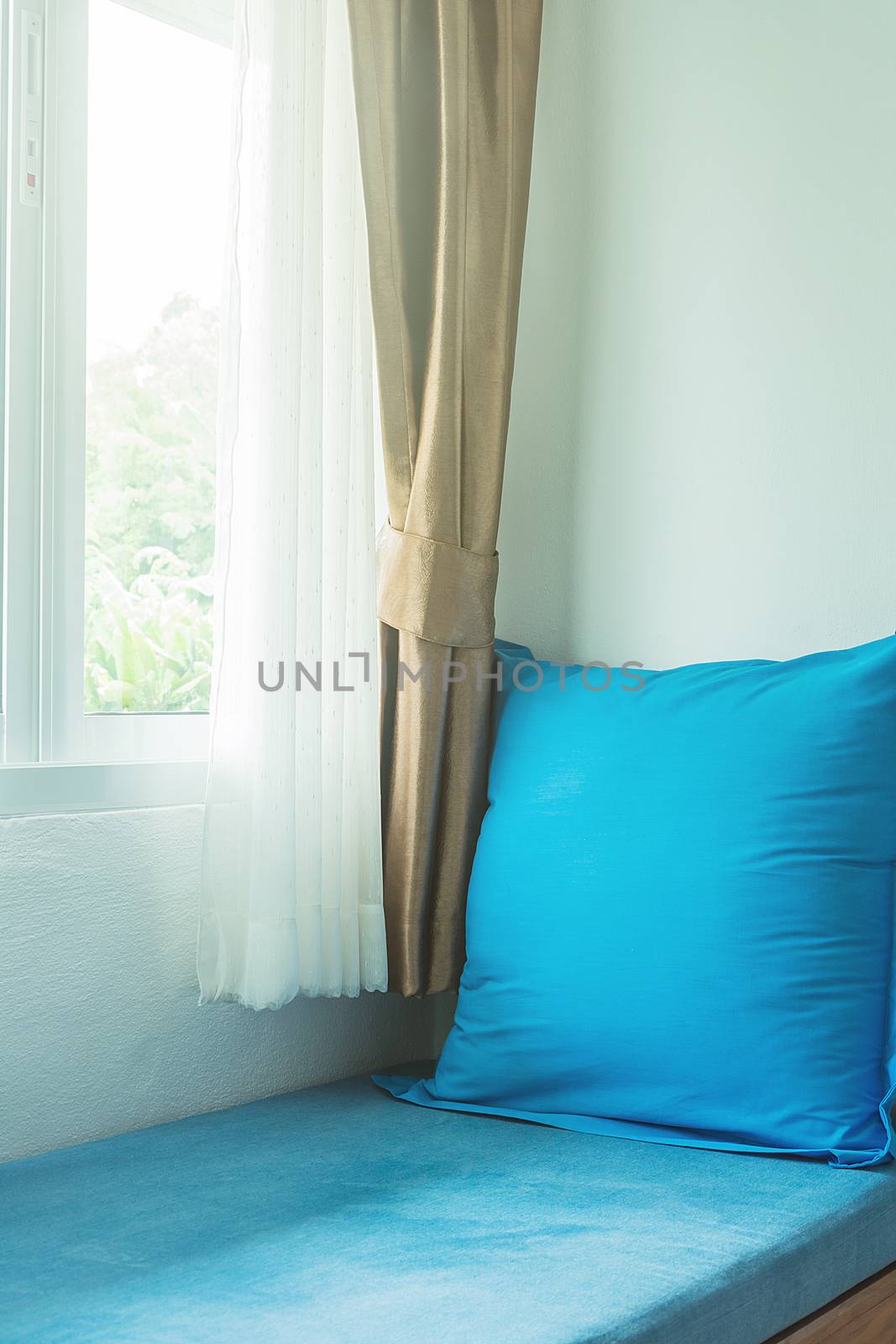 blue pillow near in glass window with soft light in the morning