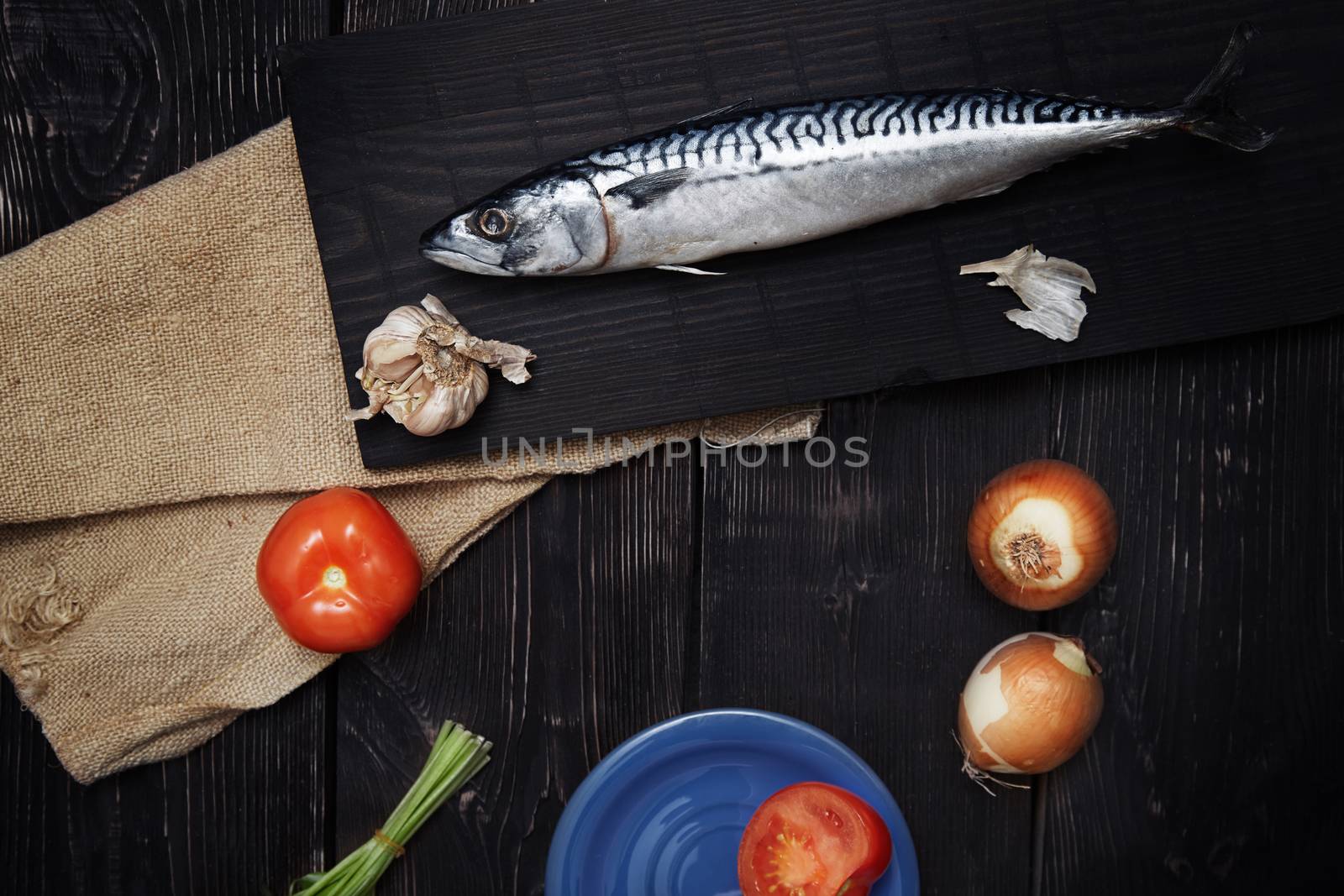 Mackerel and vegetables on a wooden table. Horizonal photo