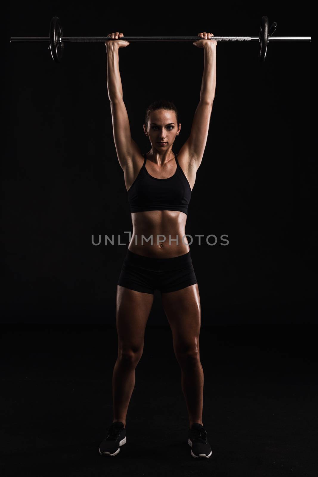 Shot of a beautiful young woman in a workout gear lifting weights