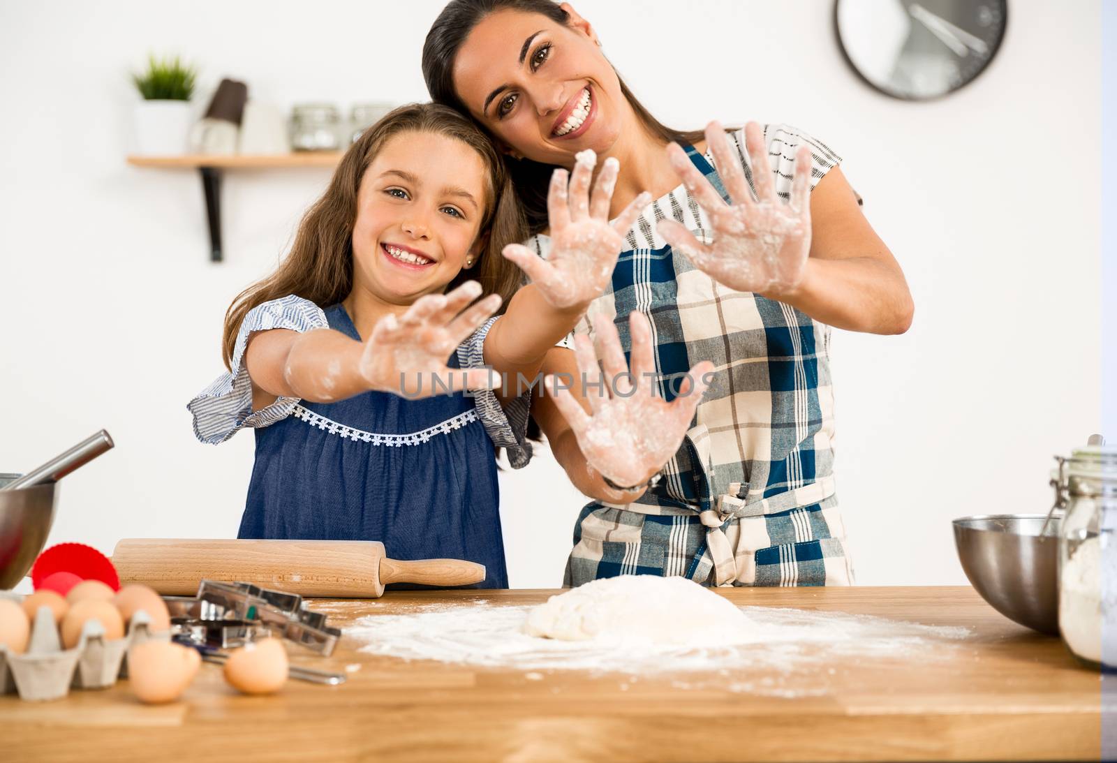 Shot of a mother and daughter having fun in the kitchen and learning to make a cake