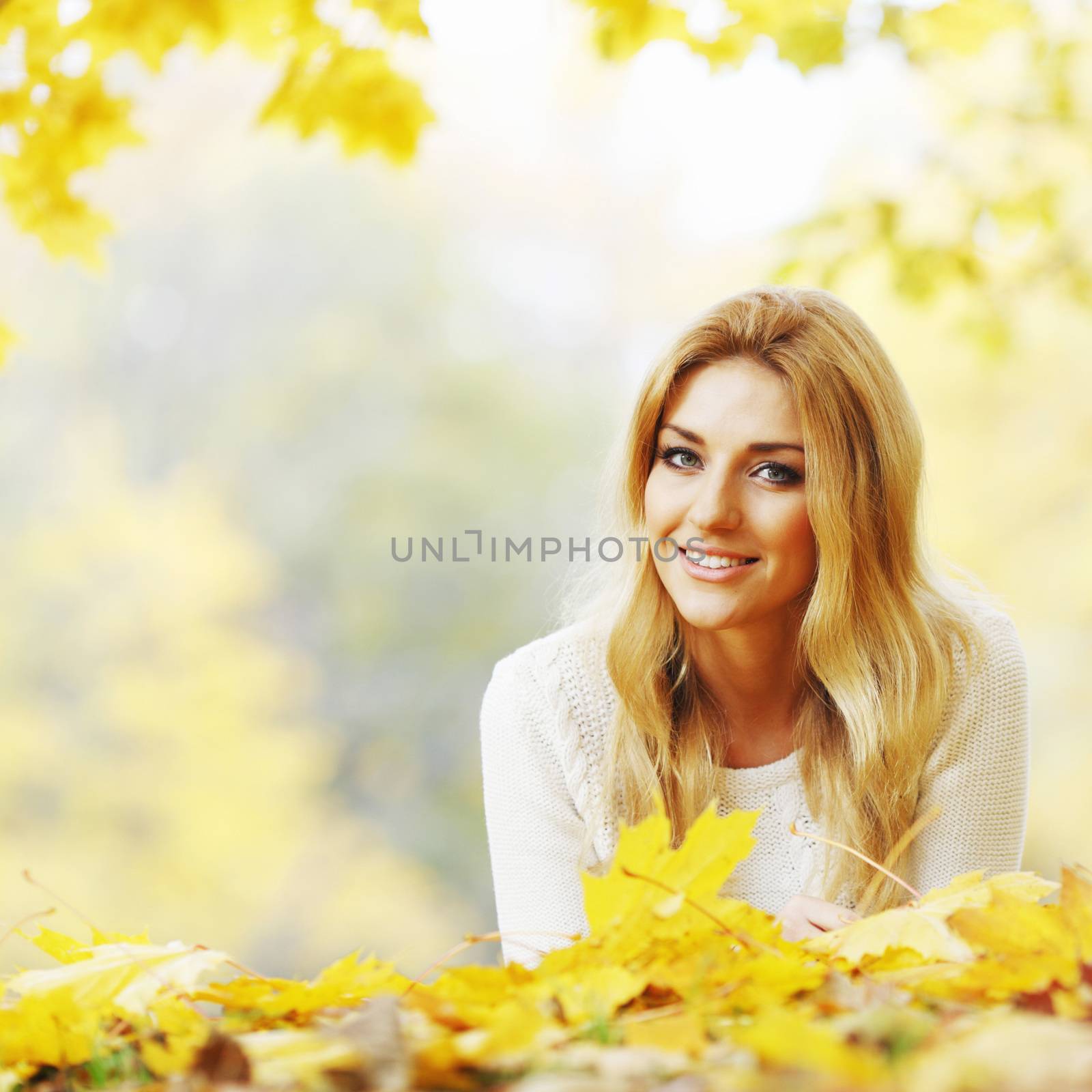 Woman laying in autumn park by Yellowj