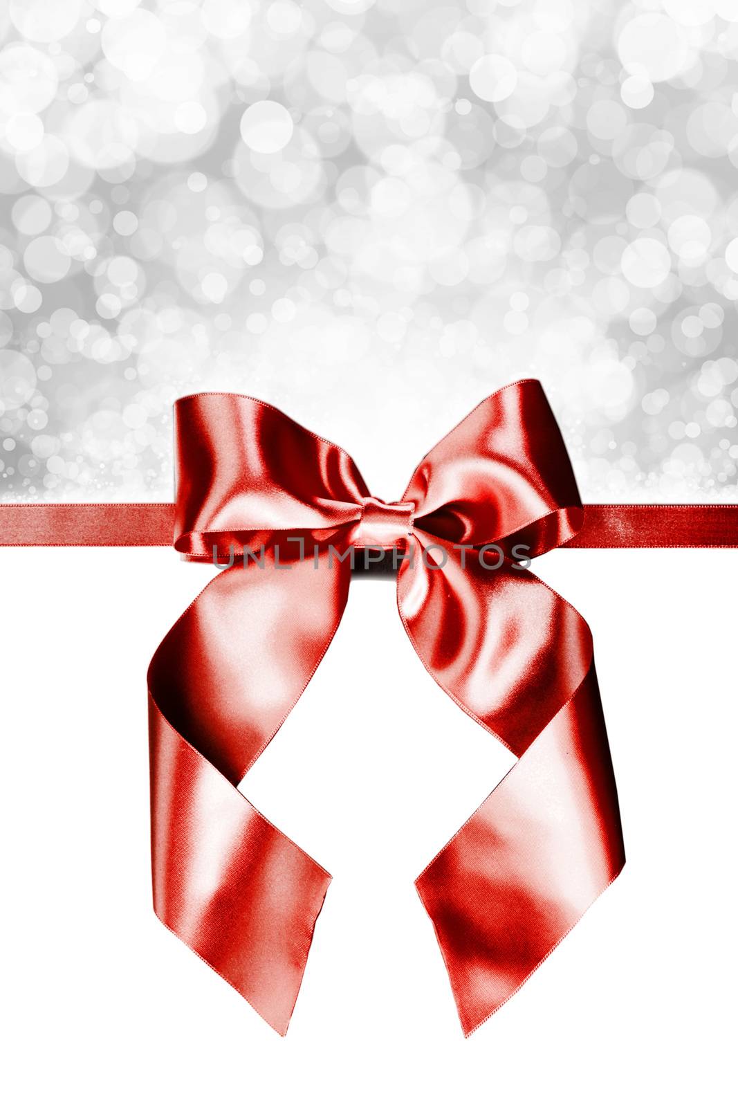 Red gift ribbon bow and bokeh lights isolated on white background