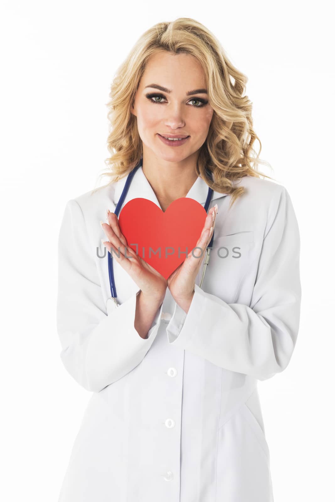 Smiling female doctor holding heart shape paper studio portrait isolated on white background