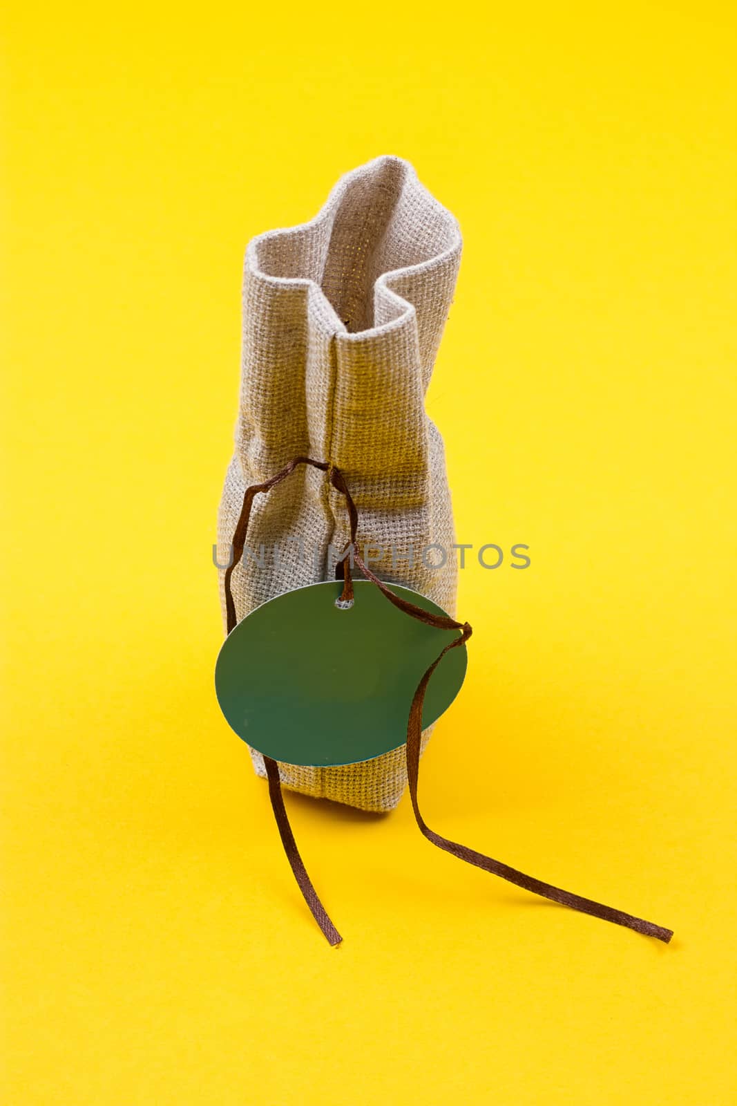 Bag of sackcloth with a blue tag on a yellow background
