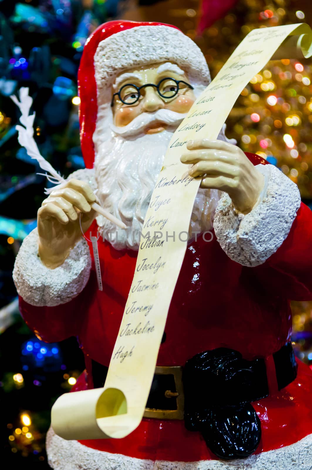 small santa clauss statue with a list of names