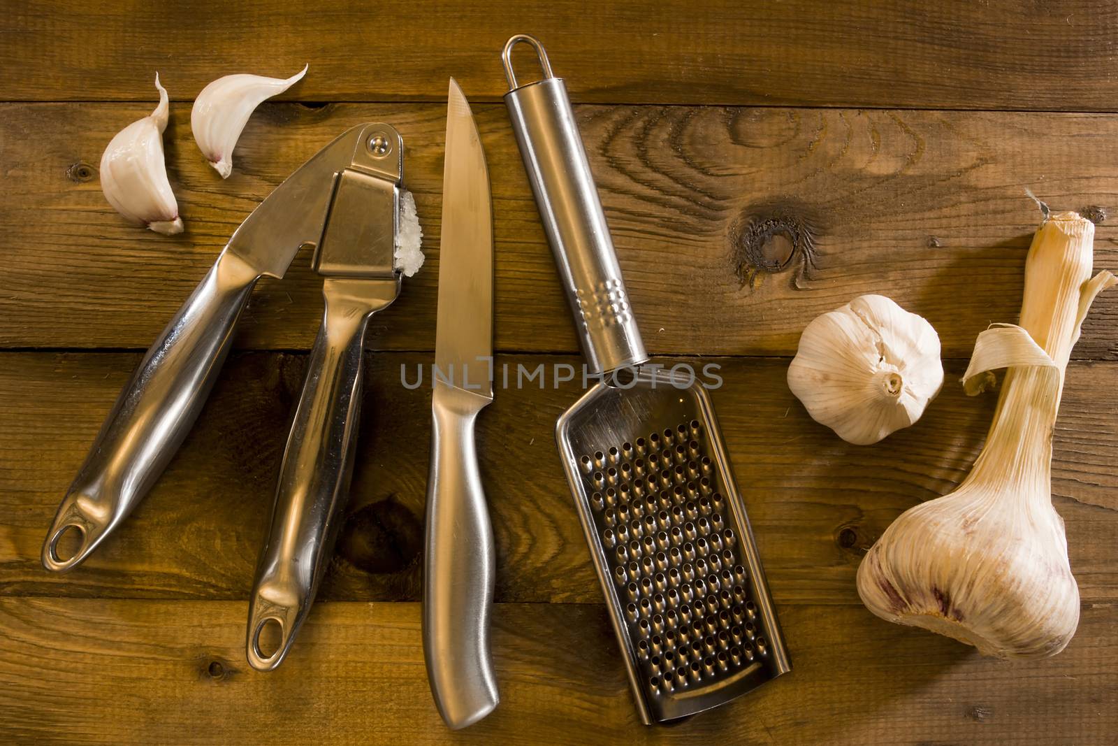 Tools for chopping garlic and garlic on a wooden table