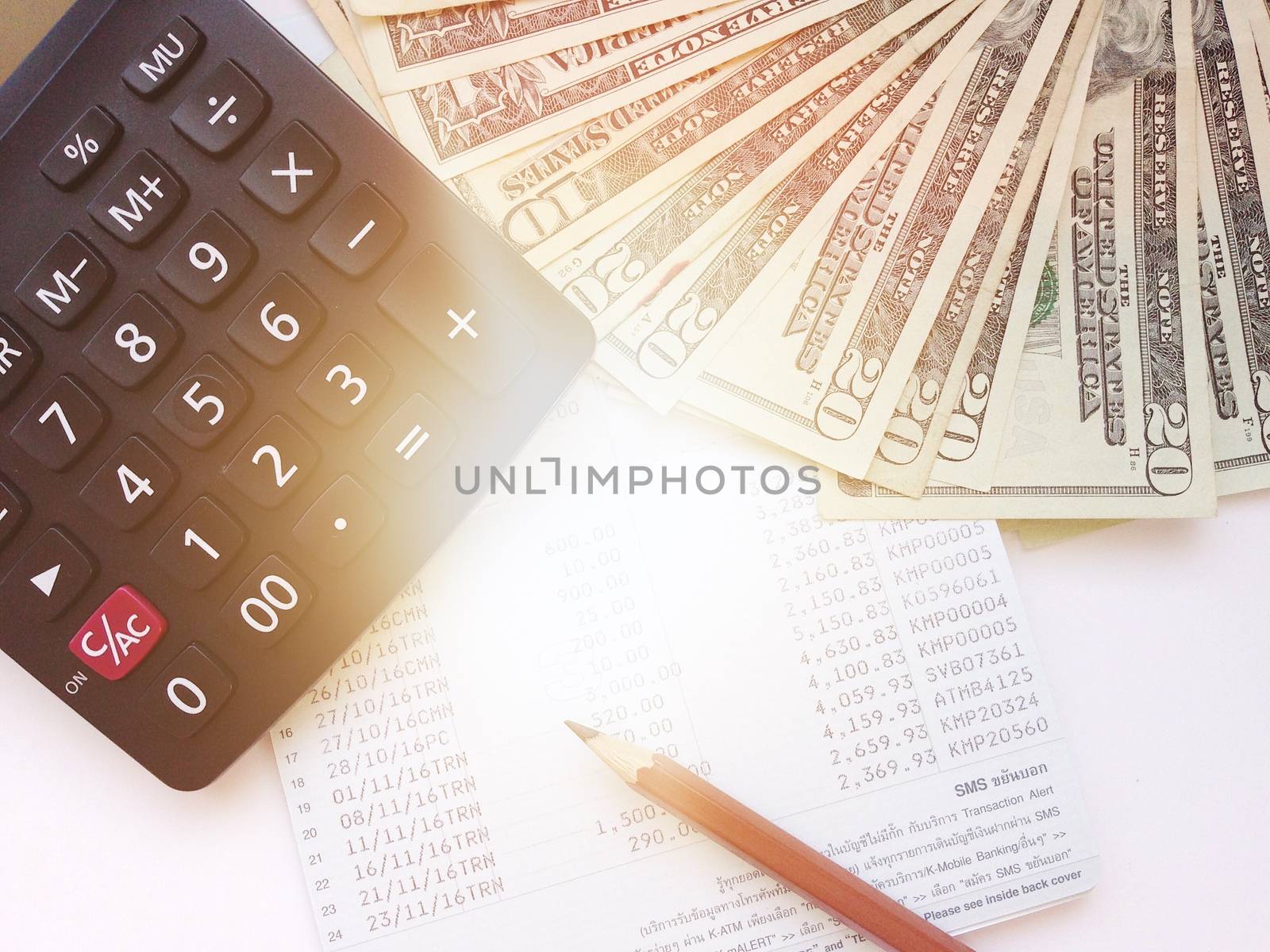 Business, finance, savings, banking or loan concept : Pencil, calculator, money and savings account passbook or financial statement on white background