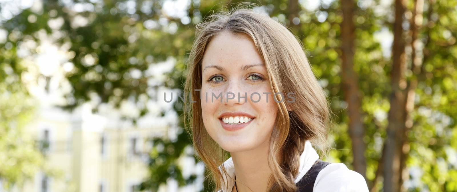 Portrait of young happy beautiful girl with freckles on her face by Nobilior