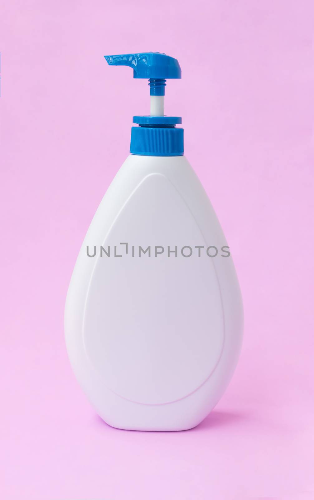White lotion bottle on pink background, beauty skin care concept